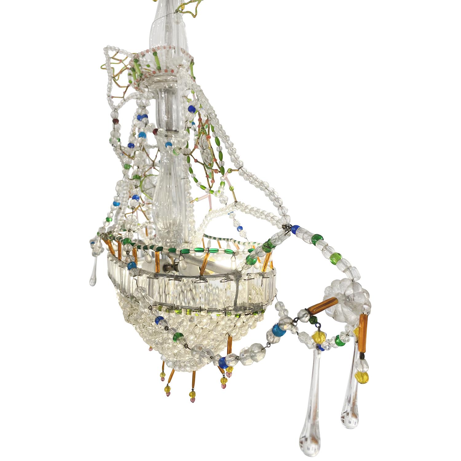 A colorful, vintage French Art Deco sail ship boat pendant made of hand blown cut crystal glass, in good condition. The detailed Parisian ceiling lamp is supported by a chrome beam, particularized by hanging prism glass pieces. The small chandelier