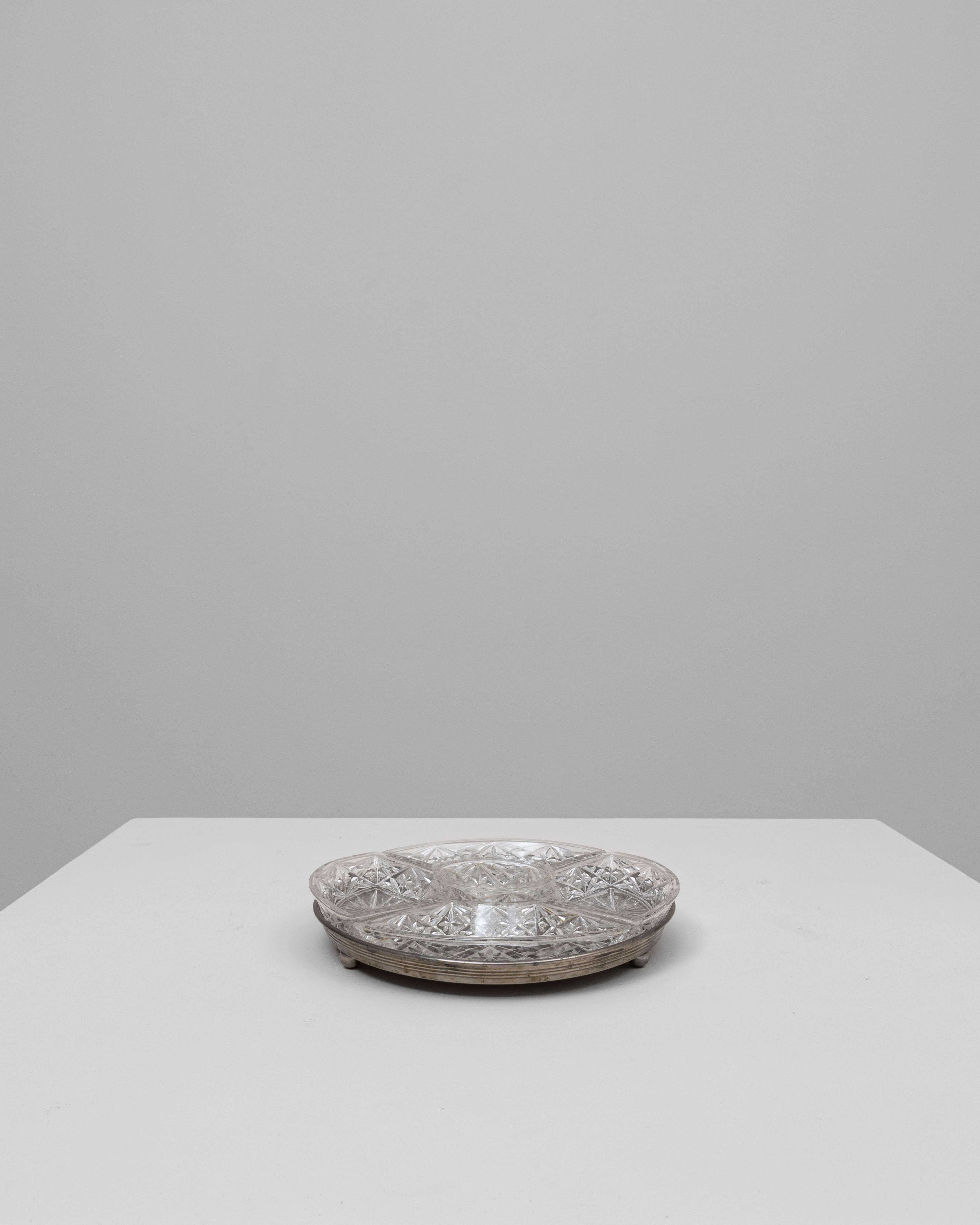 Ce plat de service en cristal français du XXe siècle sur une base en argent présente un magnifique design facetté composé de cinq sections de cristal amovibles disposées autour d'un bol central. Chaque pièce est taillée avec des motifs géométriques