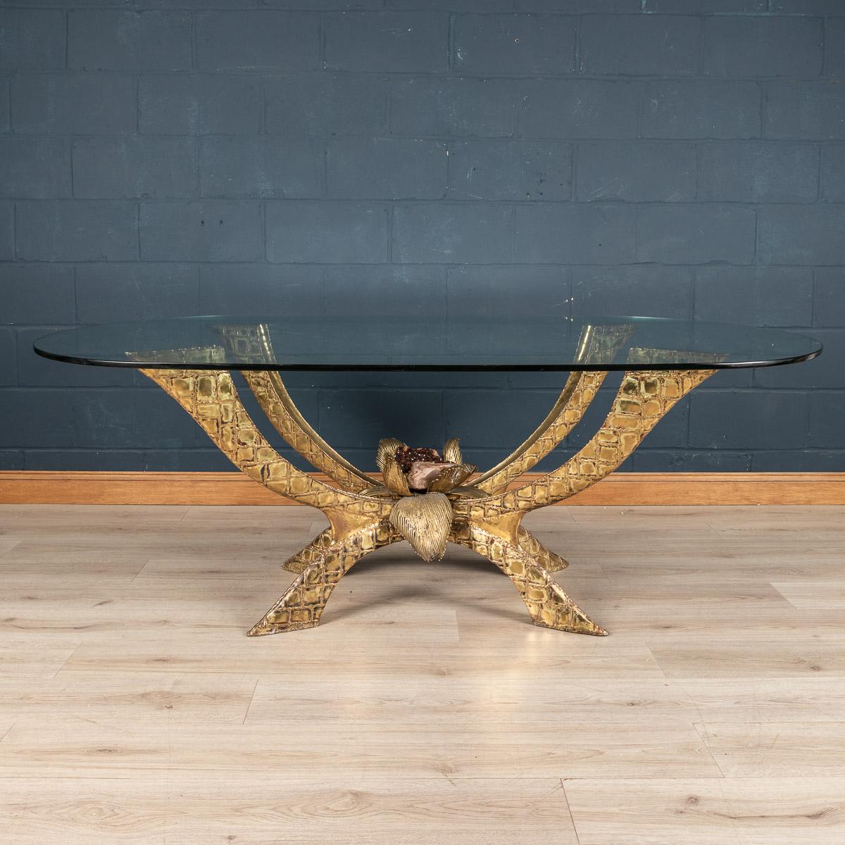 A rare and impressive dining table by Jacques Duval-Brasseur, made in France around the 1970s. The thick oval glass is supported by a sculptural frame entirely made of brass, encompassing a smoked quartz crystal to the centre. Signed to the