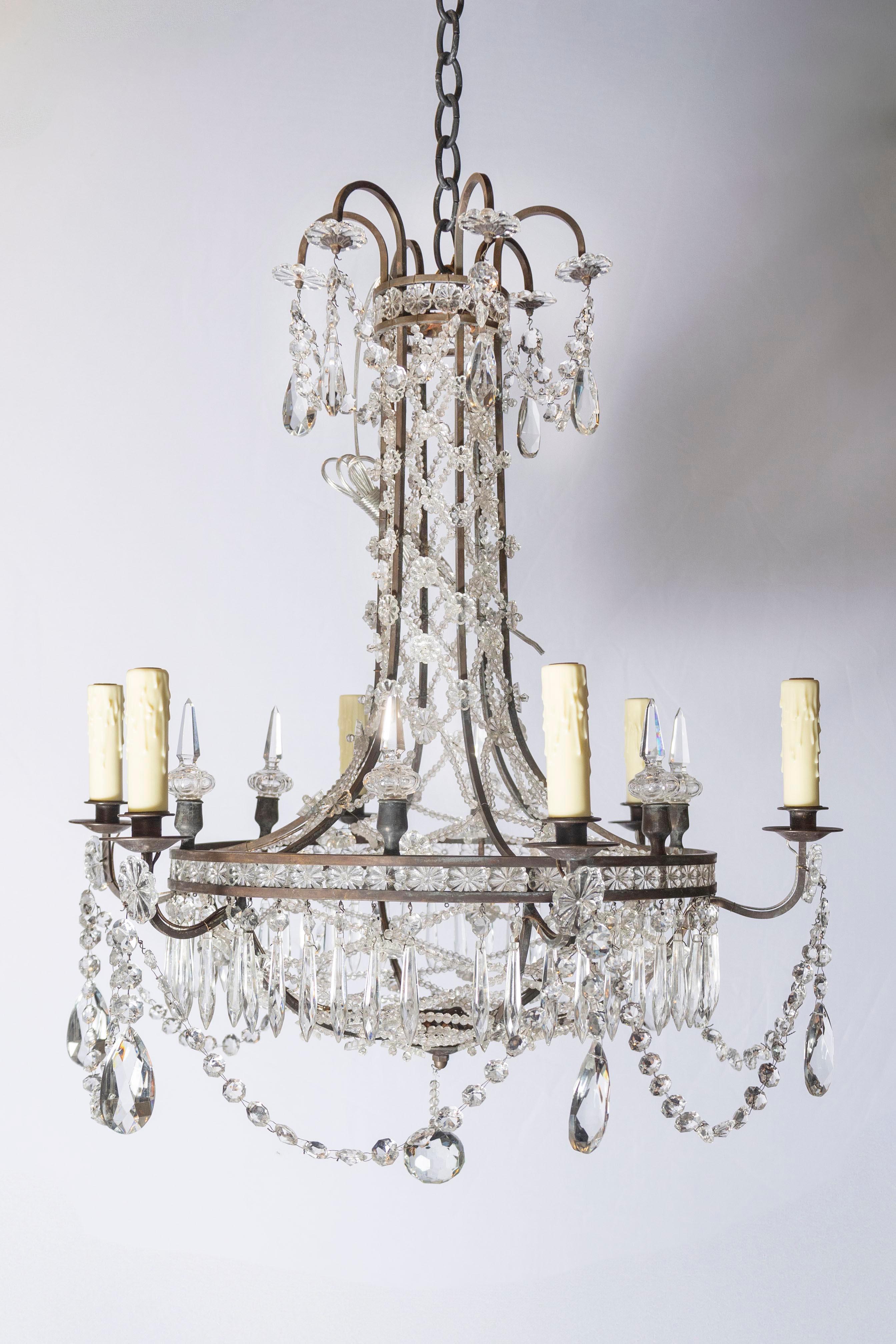 Raffiné et magnifiquement composé, ce lustre français du XXe siècle est un exemple frappant du style Directoire Revival, où la clarté néoclassique rencontre l'élégance discrète. Ses proportions gracieuses et son ornementation sobre reflètent la