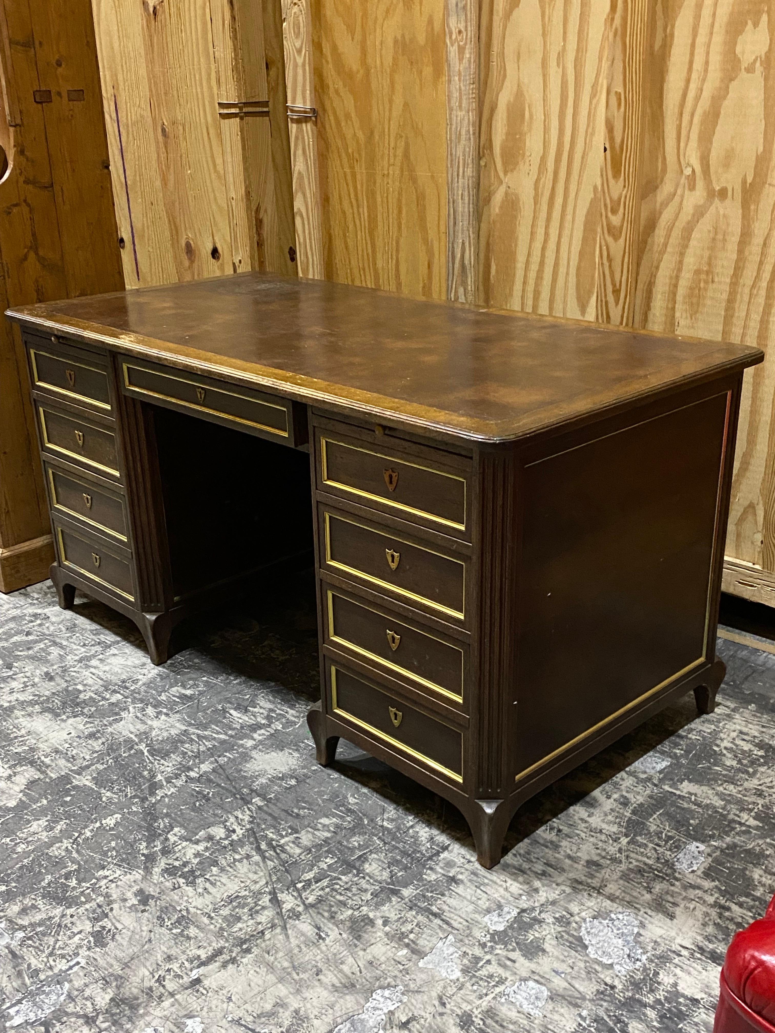 20th century French Directoire Style mahogany and brass writing desk from W. & J. Sloane
A classic design and well proportioned desk with plenty of drawers for organization. Eight Drawers, four on either side of central knee hole, and a wider