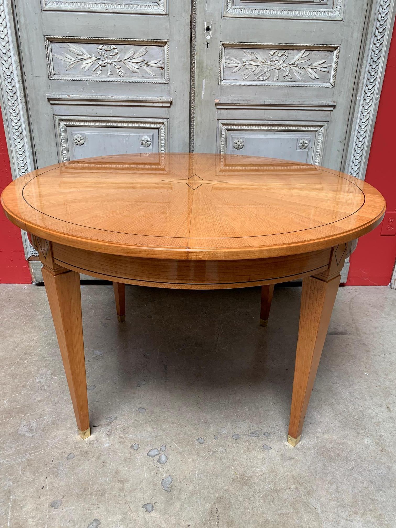 French Directoire style mahogany veneered table with a parquetry inlay from the 1920s. This table has four square tapering legs, ending with a squire tapering bronze sabot. The parquetry is a contrasting color to the golden mahogany of the table.