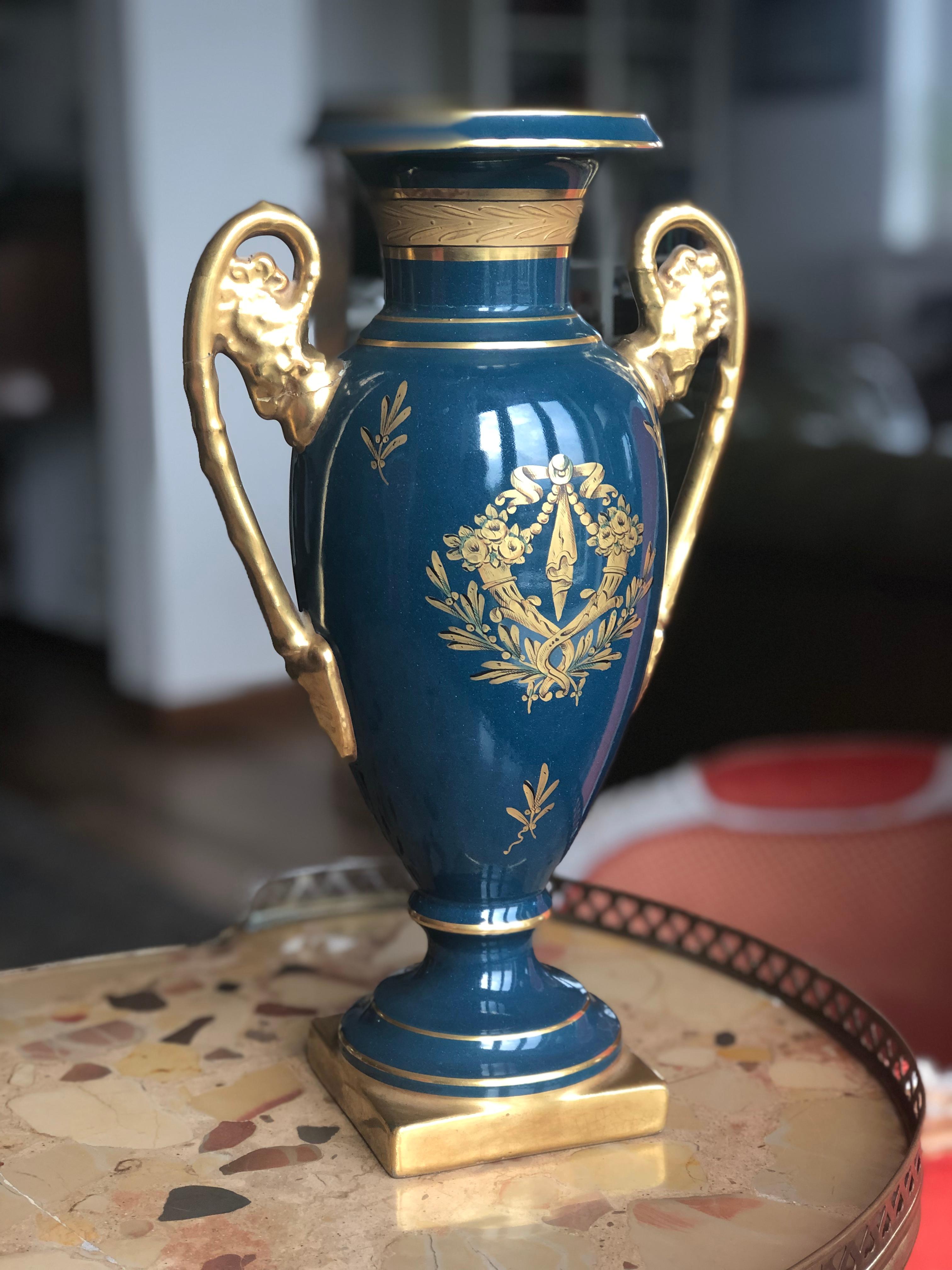 Amphora-shaped French vase in the Empire style, circa 1920. The vase is in marine-blue background with gold decorations in the spirit of Sèvres. Round neck surrounded by gold line, gilded stylish handles in the Empire style, just like the shape and