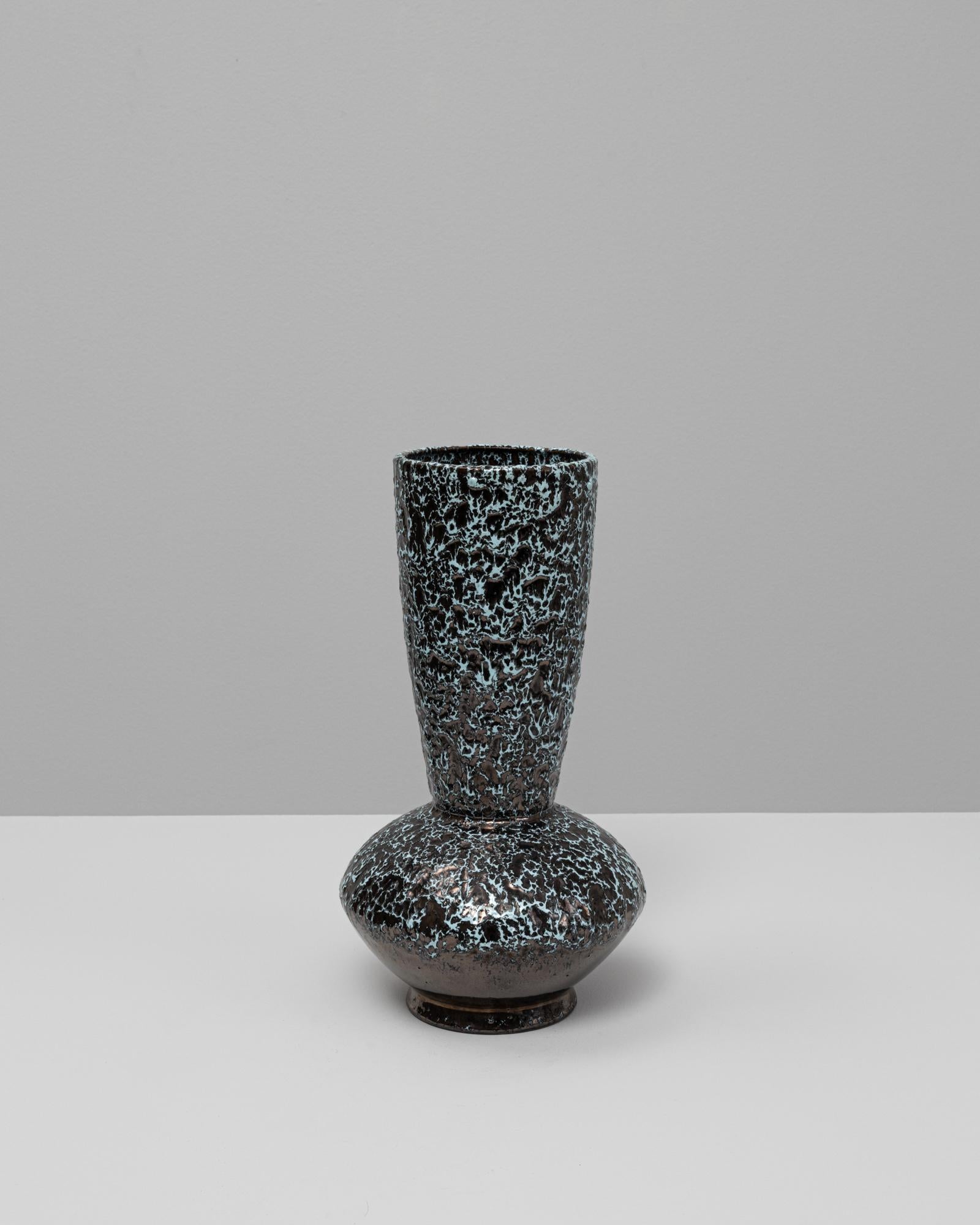 Questo vaso in ceramica di lava grassa francese del XX secolo presenta una forma audace e scultorea e uno smalto ricco di texture, emblematico dello stile di lava grassa della metà del secolo. La parte inferiore del corpo si erge in un collo
