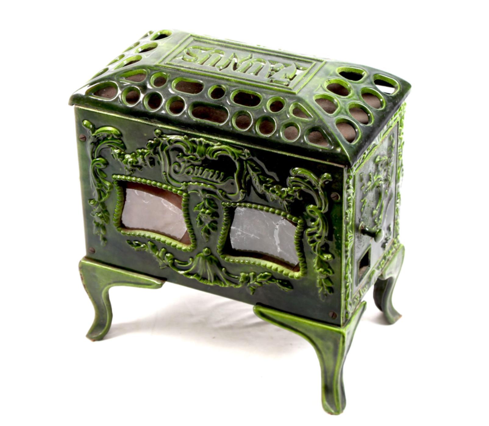 Beautiful green ceramic stove FAUNUS made in France, circa 1920. The wood to be loaded from small side door and fire to be seen from two small front windows. The piece is richly decorated with floral elements and ribbons.
France, circa 1920.