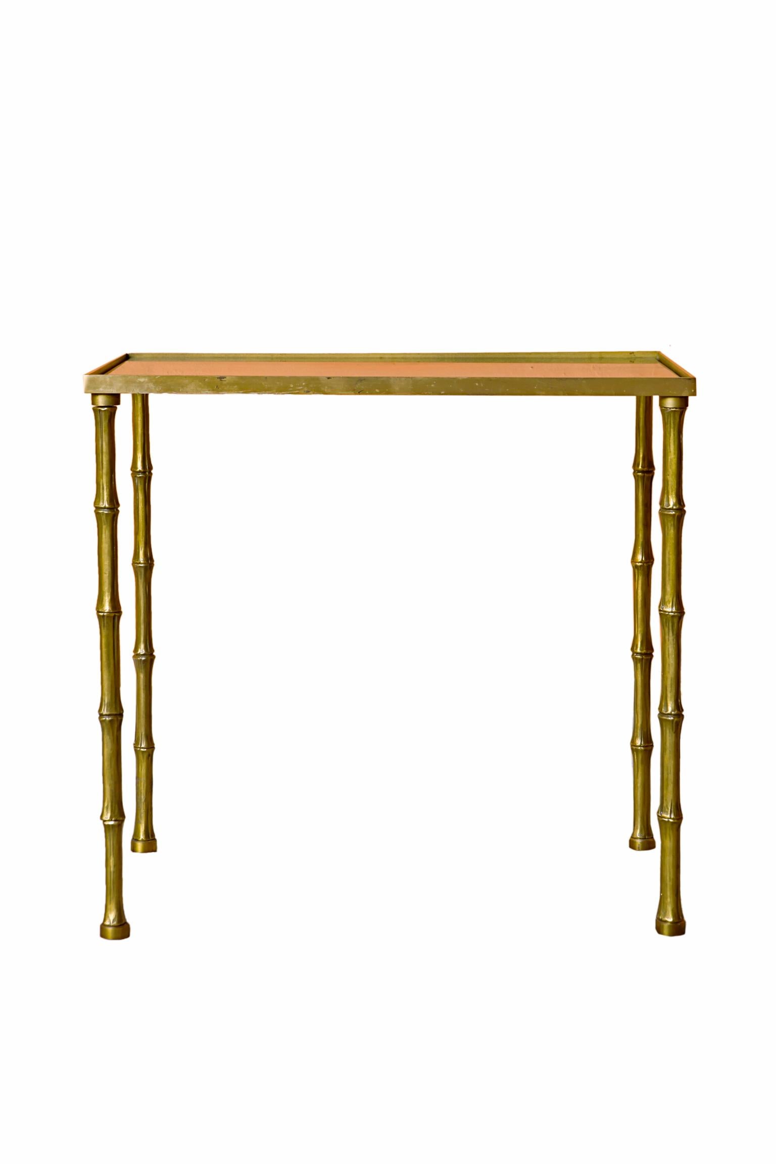 A 20th century french Maison Bagues side table or accent table.
A rectangular smoked glass top inset on a polished brass base above four faux bamboo legs.

It is part of a set together with a floor lamp. Can be bought together or separately.