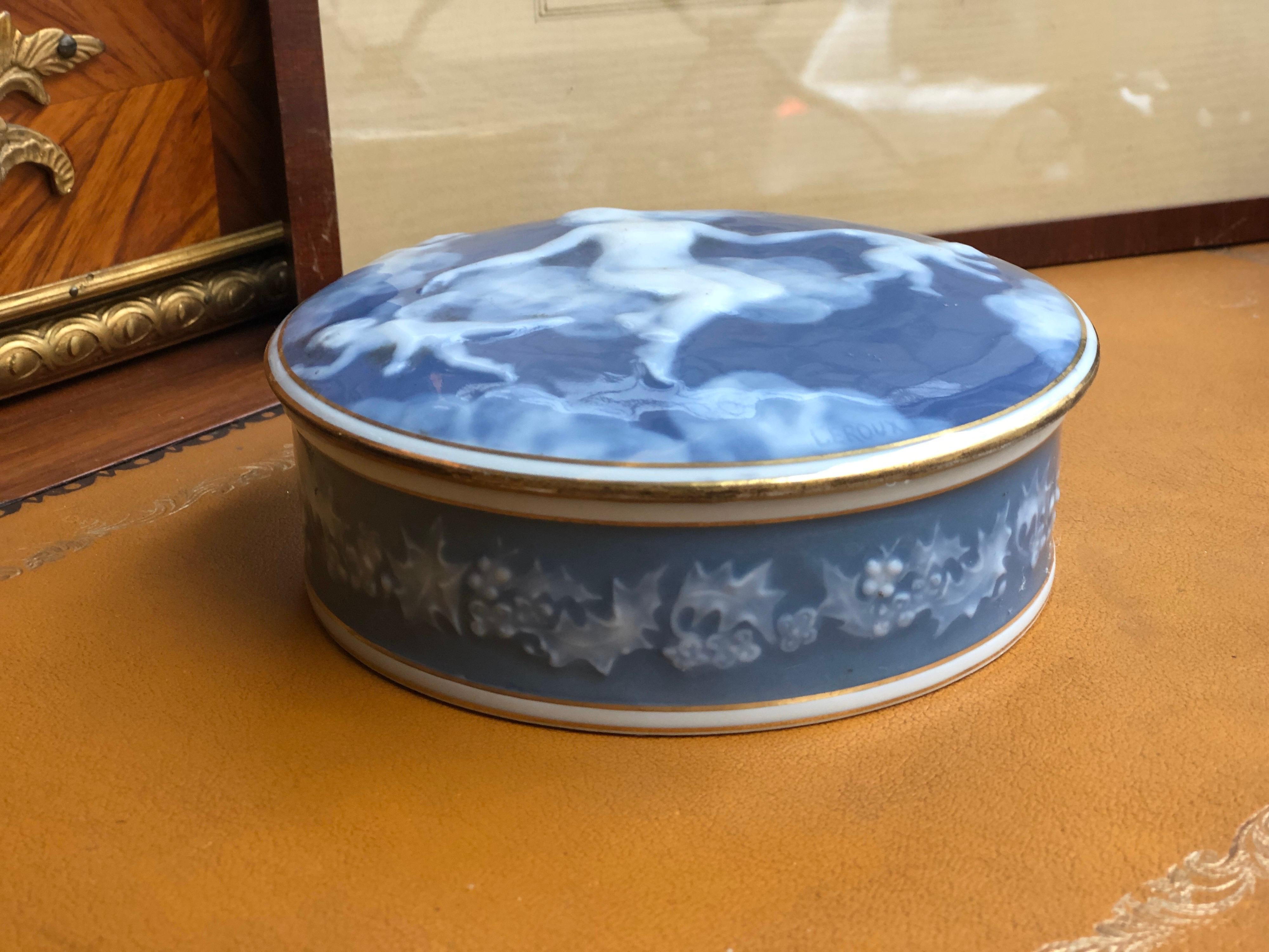 An elegant round chocolate box made in Fine blue porcelain with figures of a Goddess and two angels hiding by the clouds. Floral decoration from the side in blue and white again. Very good condition, signed on the top 