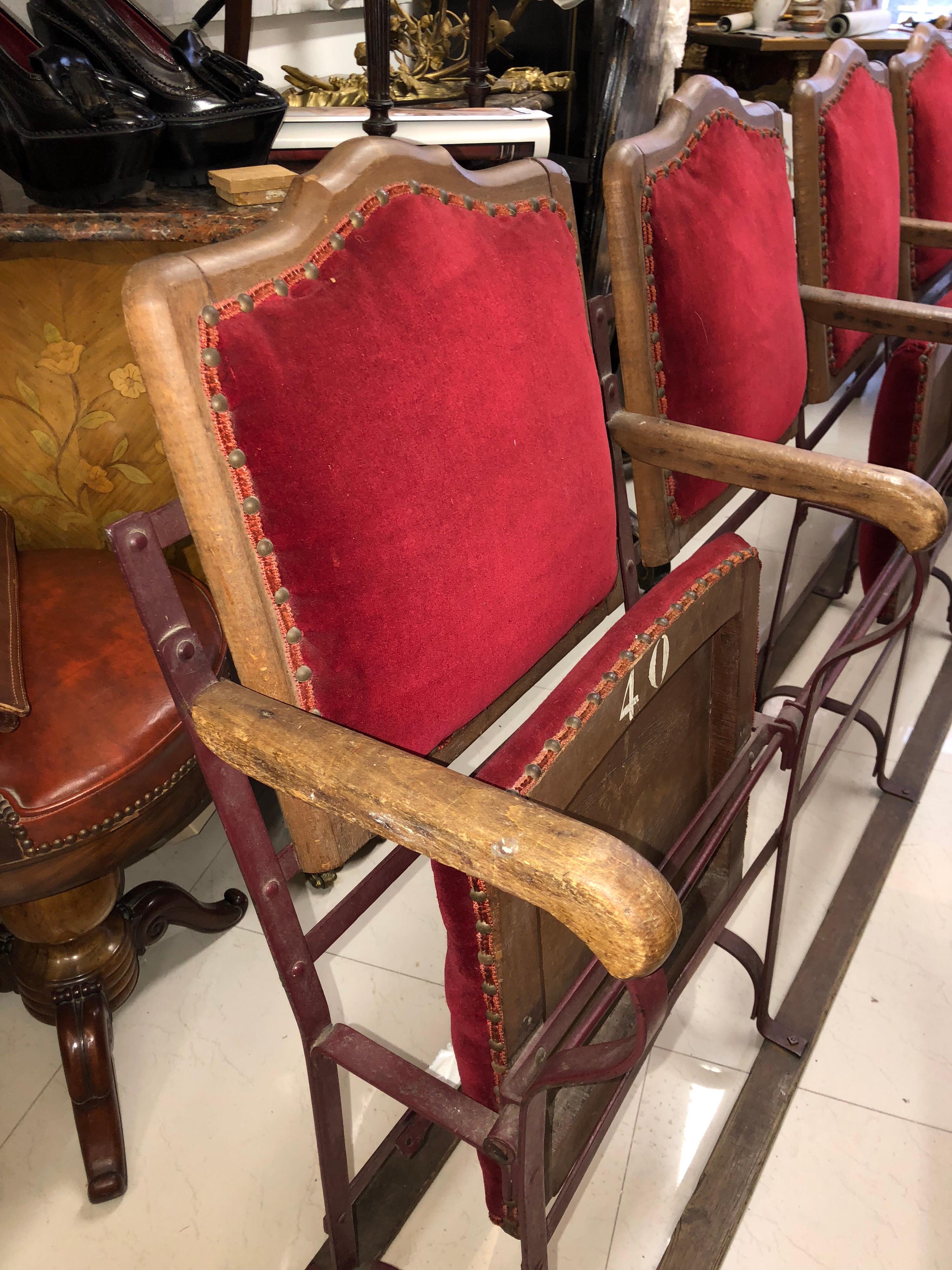 Four-seat cinema seats in wood and metal with tilting seats, upholstered in red velvet. Measures: Width 196 cm
France, circa 1920.