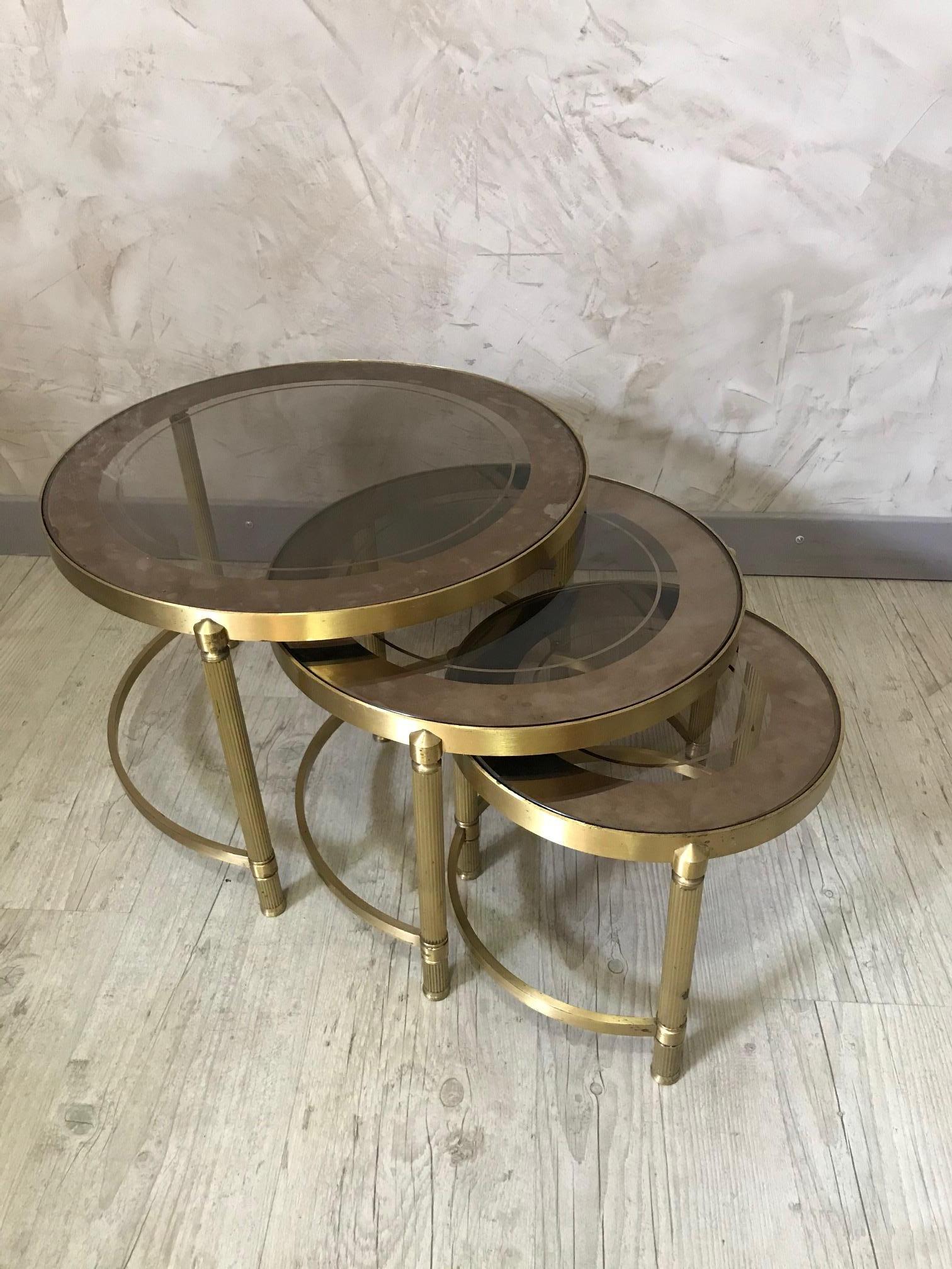Beautiful 20th century French gilded brass and mercury glass set of 3 nesting tables from the 1950s. 
The glass are removable. Each table can be tidy up under the largest one. 
Very good quality of brass and glass.
 