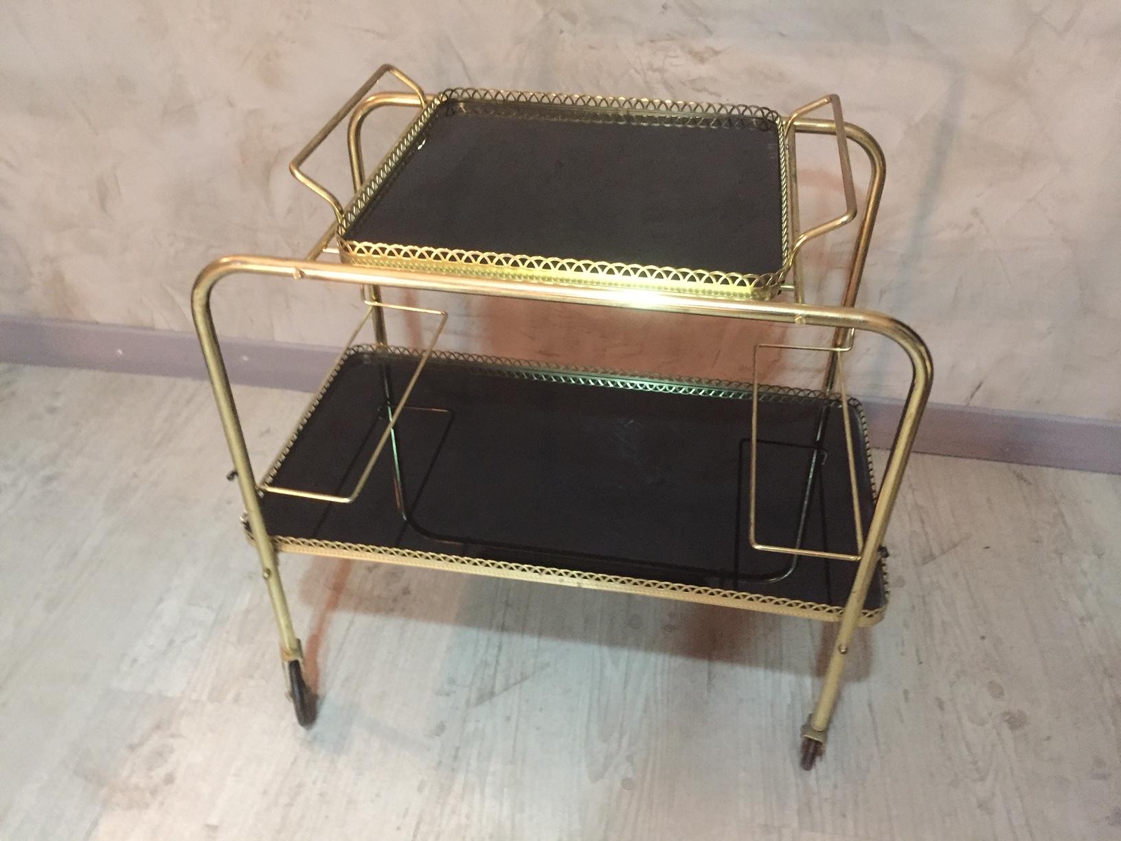 Beautiful 20th century, French gilded brass rolling cart from the 1960s.
The tray is removable and made with black glass. Gilded brass gallery.
Good condition.