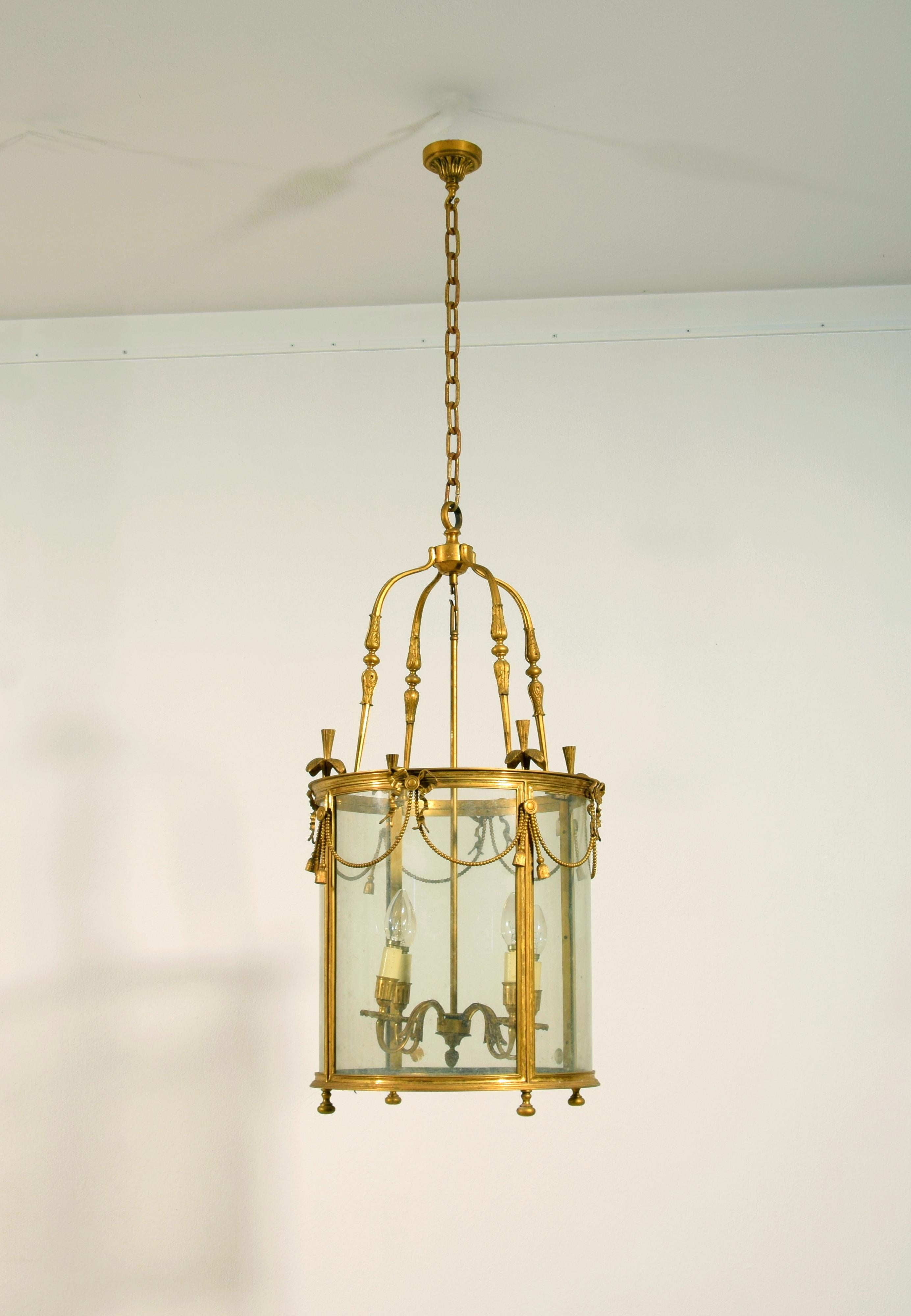 20th century, French Gilt Bronze Four Lights Lantern Chandelier

This four-light gilded bronze lantern was made in France in the early 20th century. The central element is circular with glass doors supported by a gilded bronze structure decorated