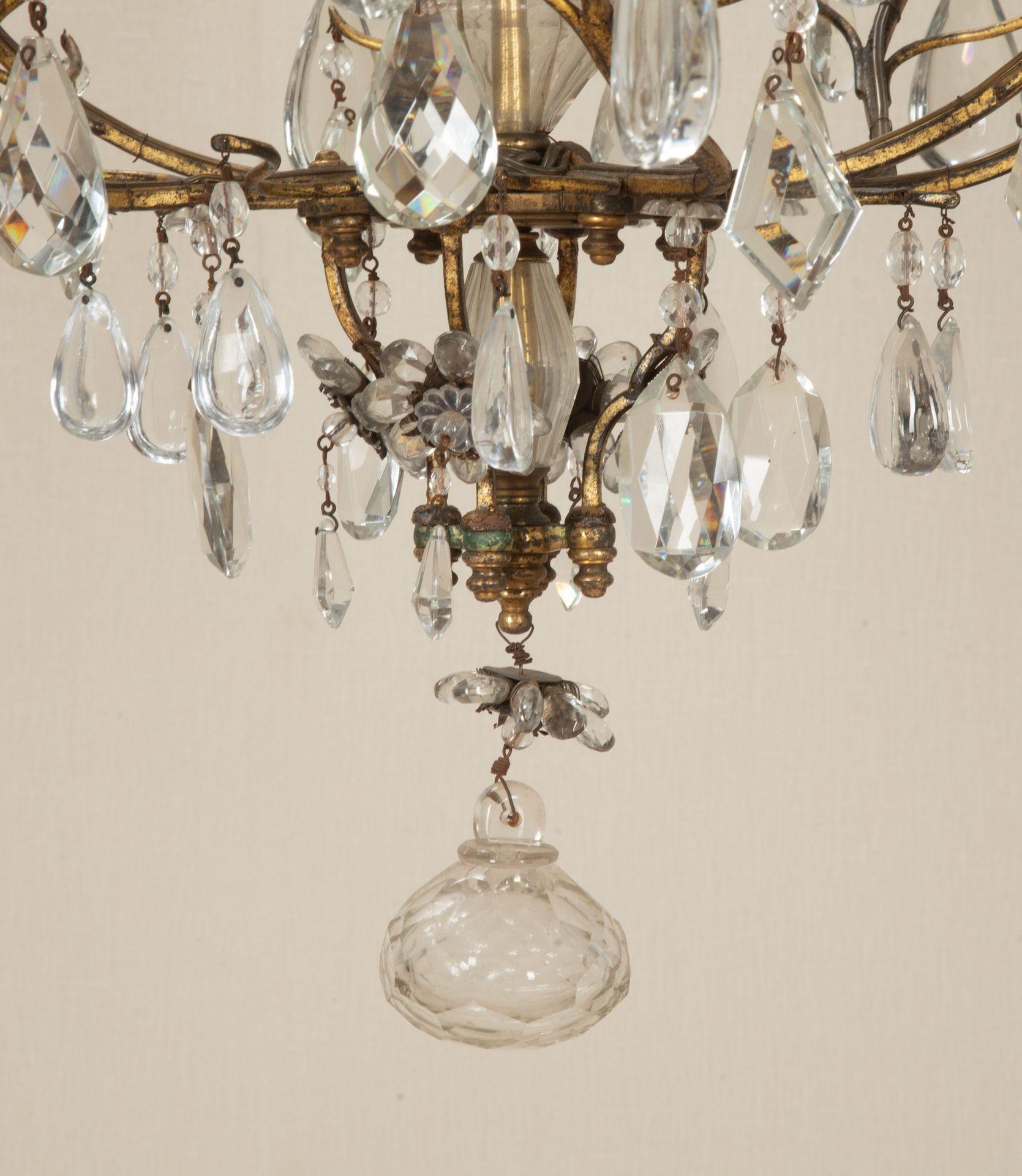 20th Century French gilt metal chandelier with glass drops and flower patterns. Circa 1950.