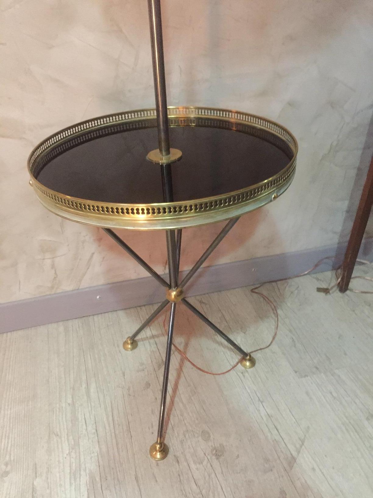 Beautiful 20th century, French gilded brass floor lamp from the 1950s. 
Small table integrated in the floor lamp. With a brass gallery. 
Tripod base. Very large lampshade.