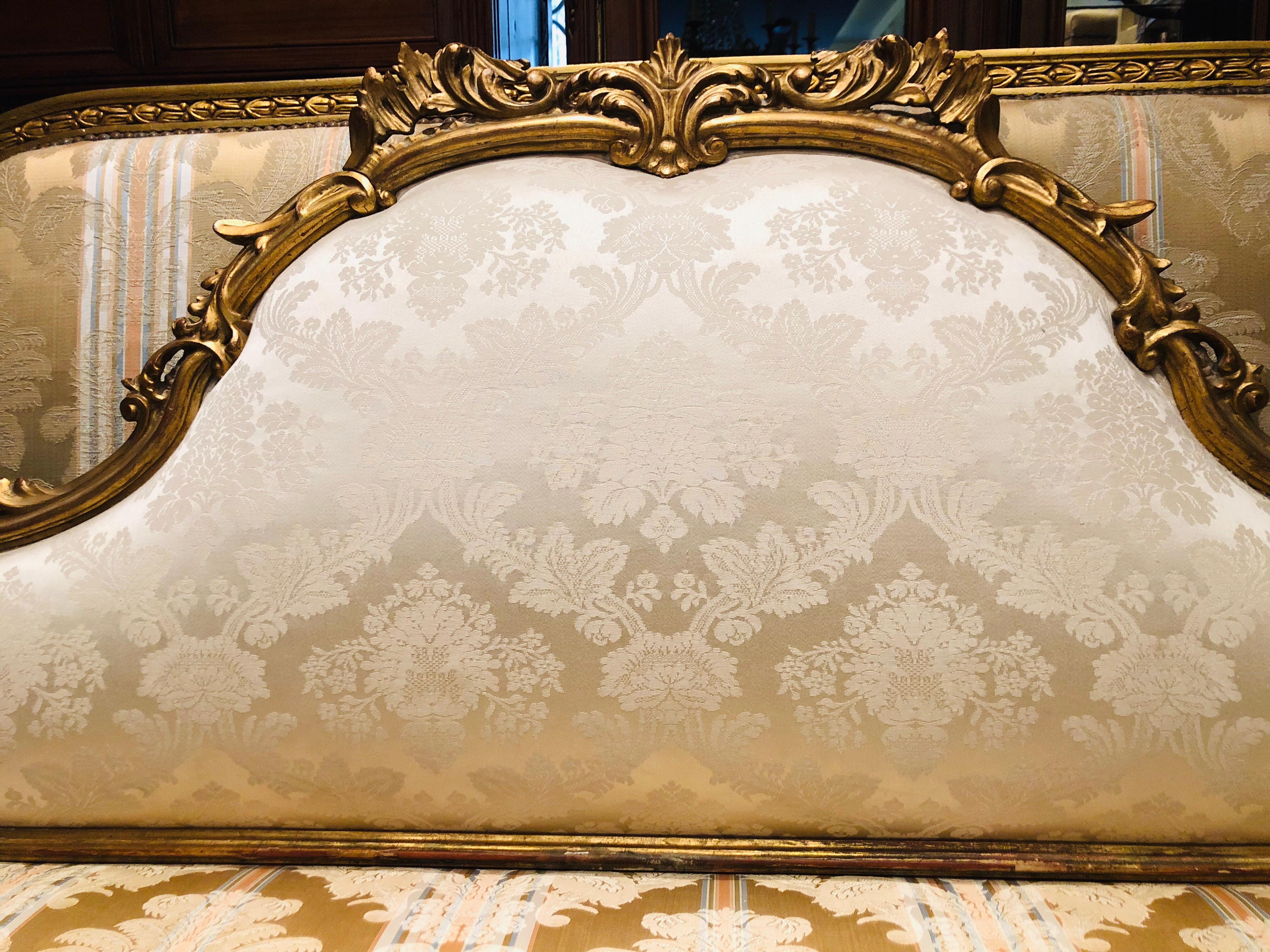 Very elegant giltwood and hand-carved bedhead with silk upholstery in light beige.
France