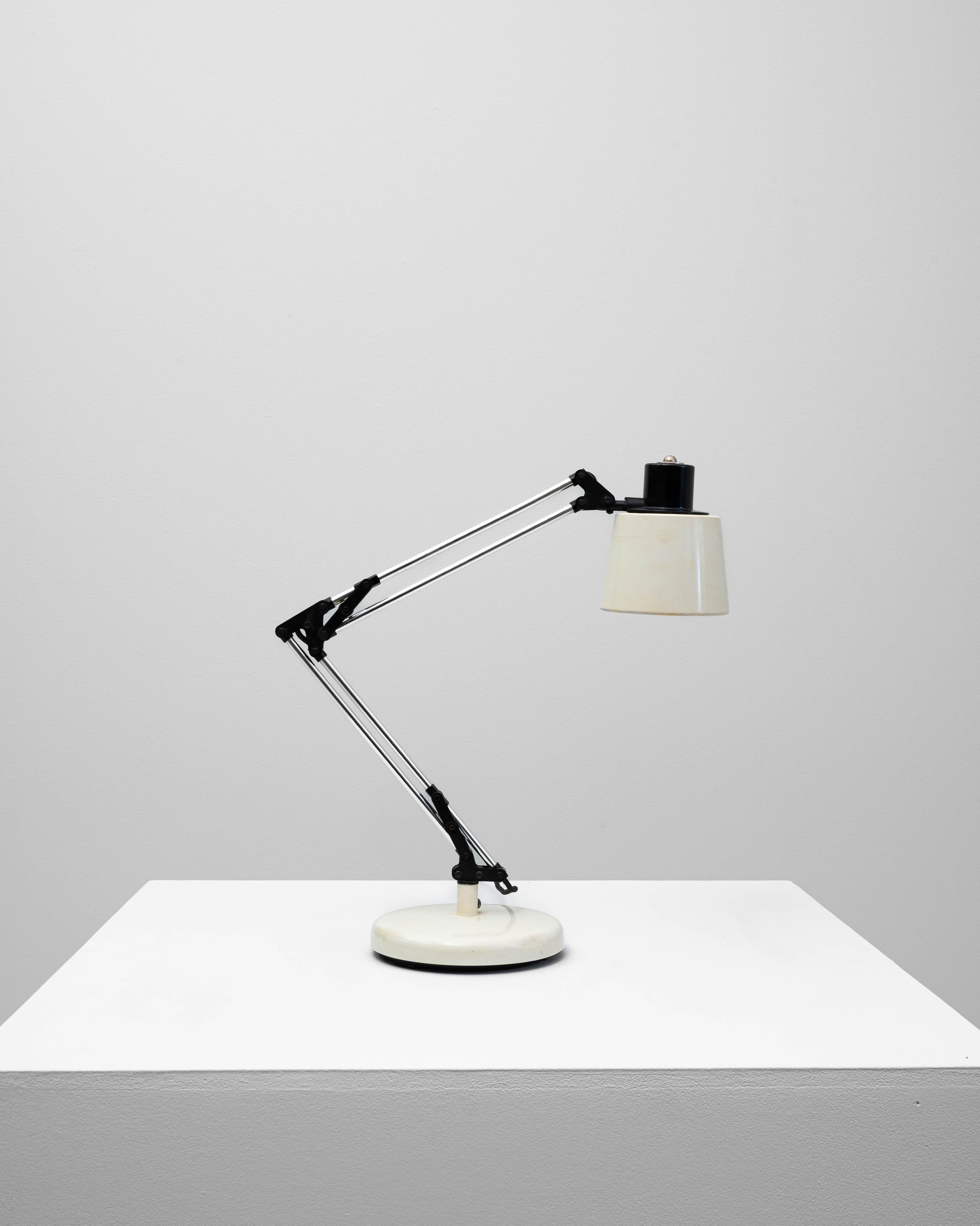 Questa lampada da tavolo Giotto di Luce Dimensioni, risalente al XX secolo, è un esempio di design modernista funzionale con un tocco industriale. Caratterizzata da un braccio articolato in cromo con snodi neri, la lampada consente un posizionamento