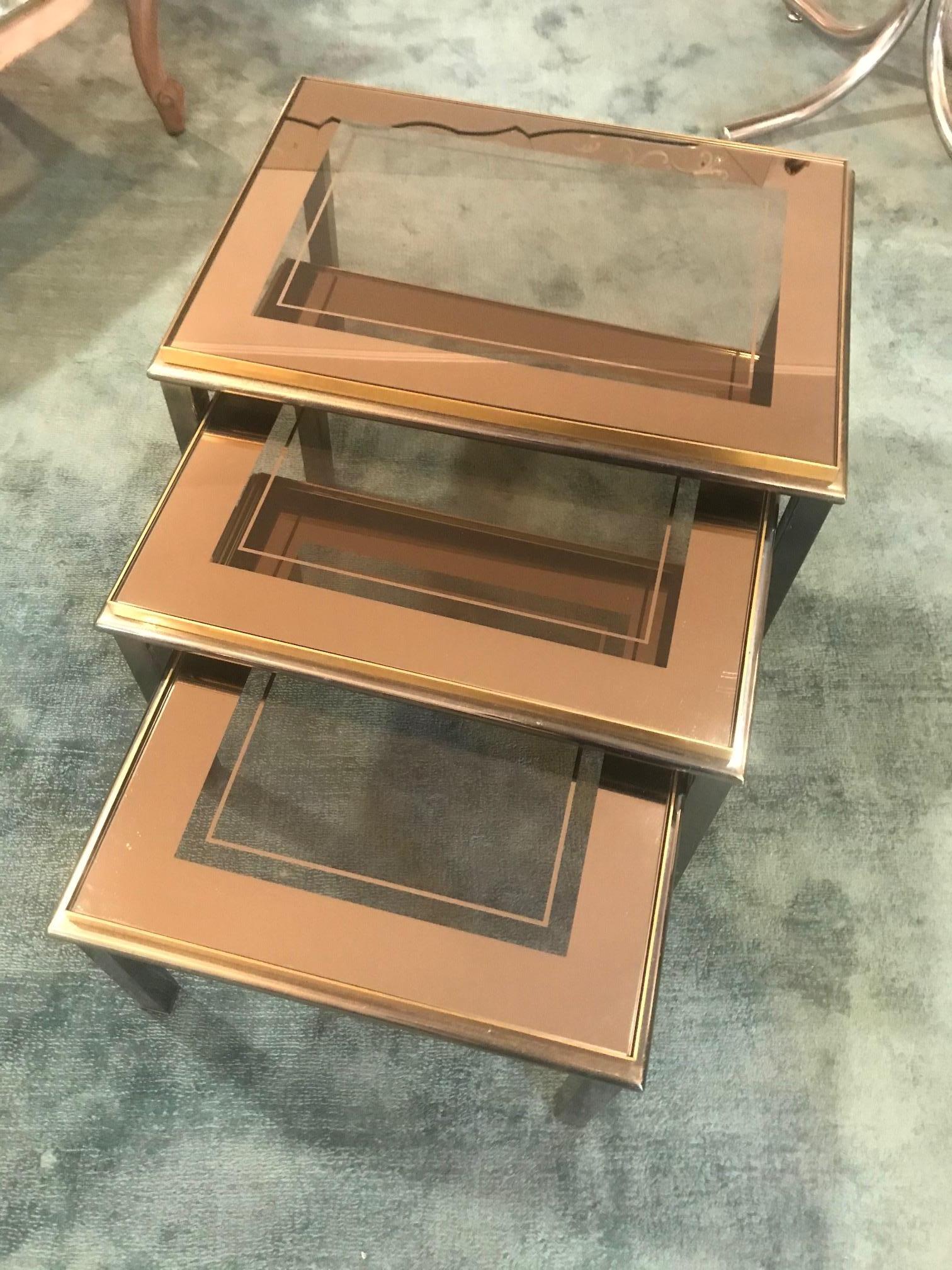 Very beautiful 20th century French smoked glass and gilded brass nesting table from the 1950s.
Good quality of the brass base (heavy).
The glass is smoked and graphic opacity.
   