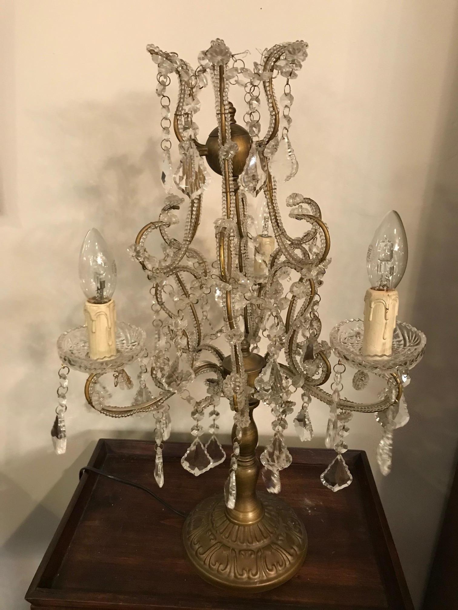 Beautiful 20th century French glass and brass table lamp from the 1940s.
3 lights bulbs. Base made with embossed brass.
Many glass pendants. Good condition.