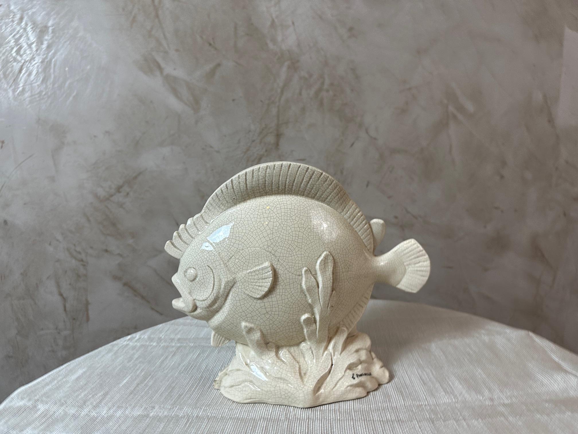 Magnífica escultura de cerámica esmaltada craquelada que representa un pez estilizado, apoyado sobre una base de inspiración marina.
Fechada en los años 30, esta pieza está firmada por L. Fontinelle, artista de renombre conocido por sus creaciones