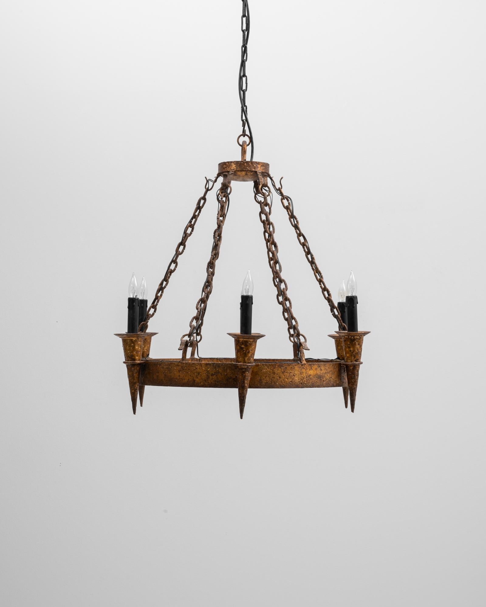 Lampadario a torcia in metallo in stile gotico revival. Questo lampadario drammatico si ispira al design gotico medievale e presenta un'audace forma ad anello sospesa da pesanti catene di metallo invecchiato che ne enfatizzano la presenza