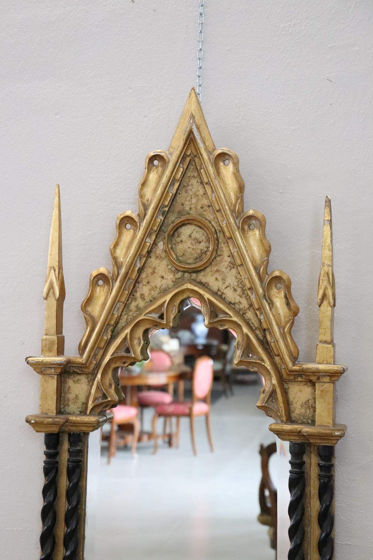 Elegant French carved and gilded wood wall mirror 1950s with refined decoration. The wood carving work is of the highest quality. Look at the details with the columns turned to the sides. The decoration reproduces the important Gothic architecture.