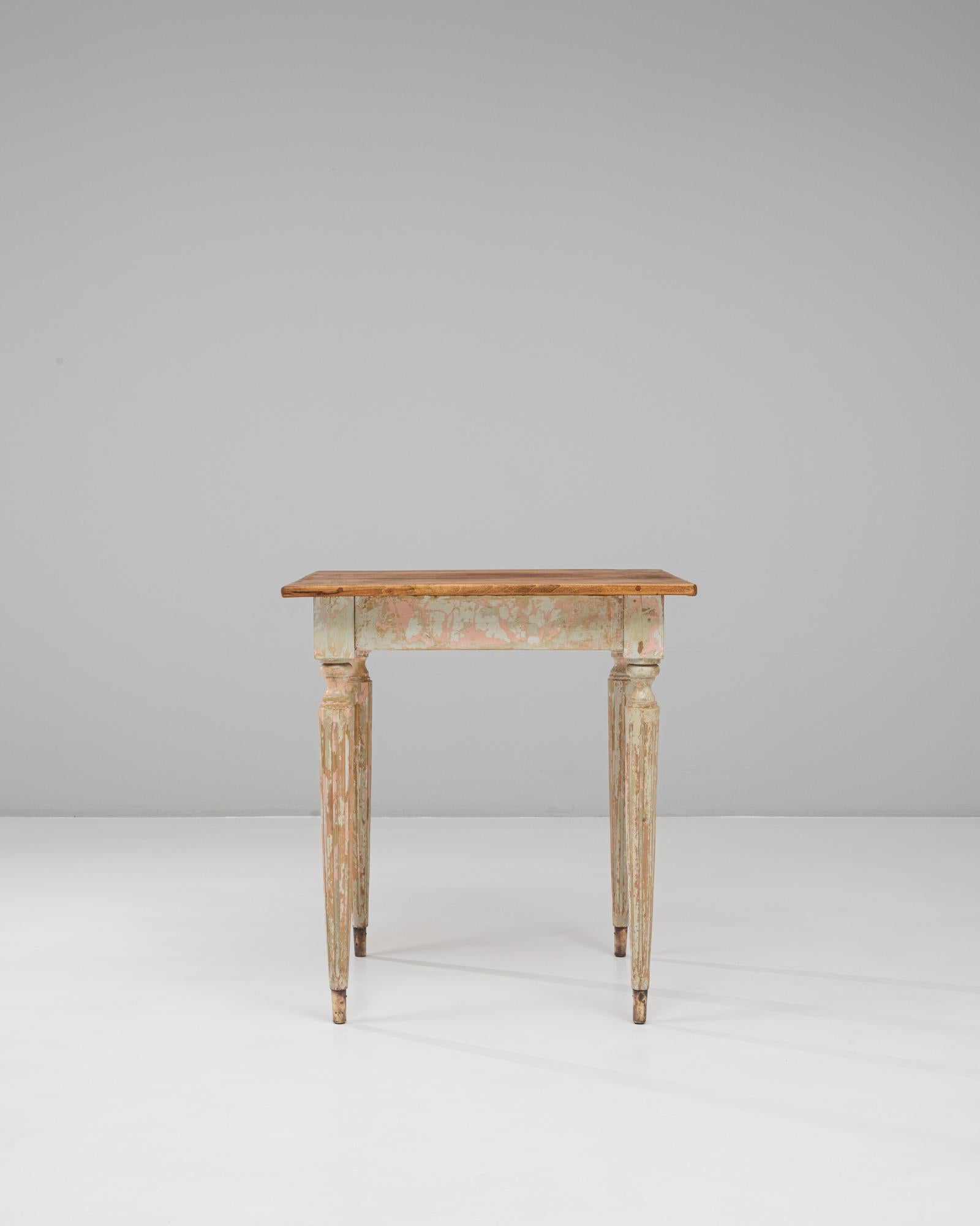 Cette table d'appoint en bois patiné de style gustavien français du XXe siècle capture l'élégance aérienne et l'ornementation sobre associées au style gustavien suédois, interprétées à travers un prisme français. La table est dotée de pieds fuselés