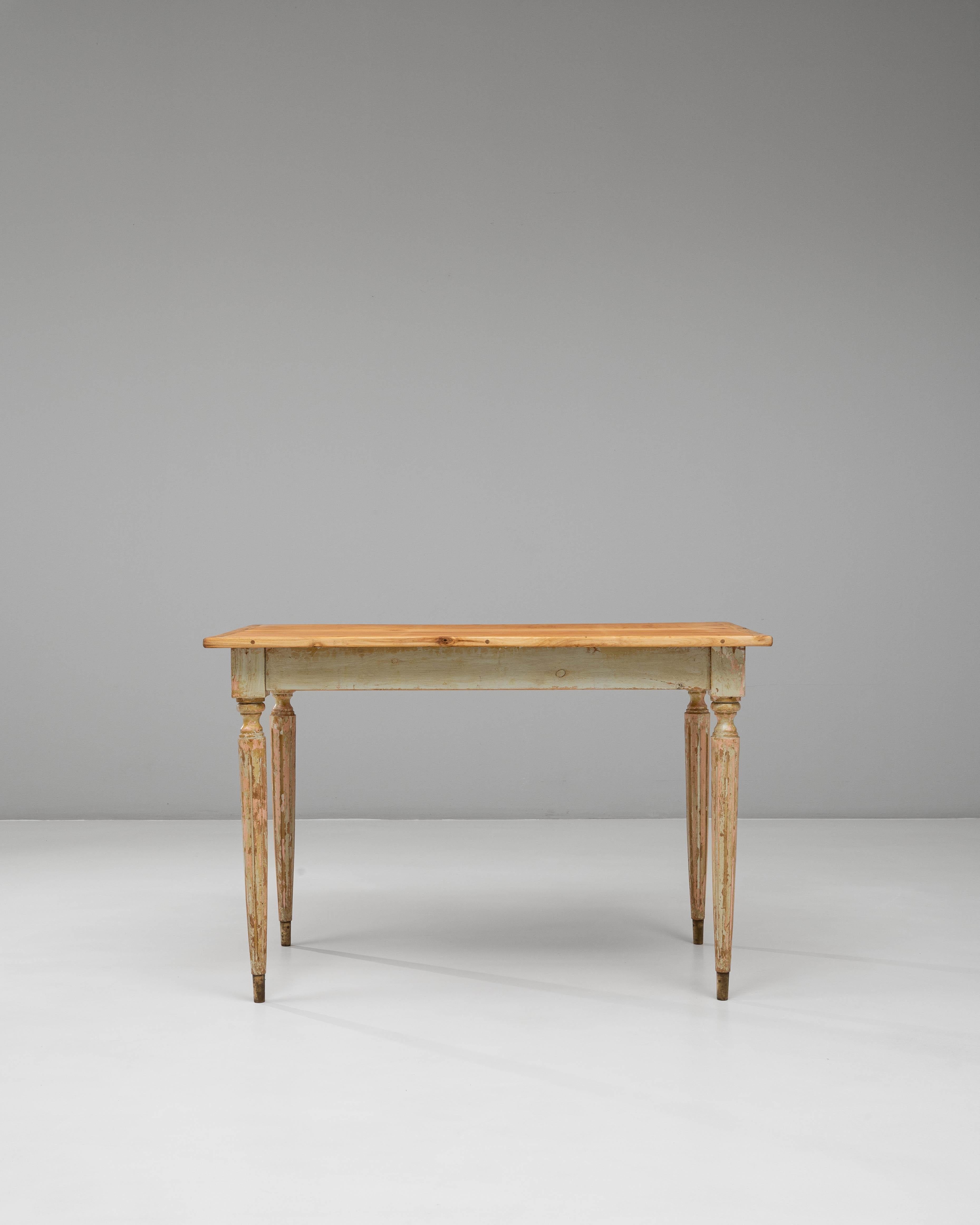 Cette table d'appoint en bois patiné de style gustavien français du XXe siècle capture l'élégance du design néoclassique grâce à sa finition sobre, adoucie par le temps, et à ses proportions raffinées. La table présente une base peinte légèrement