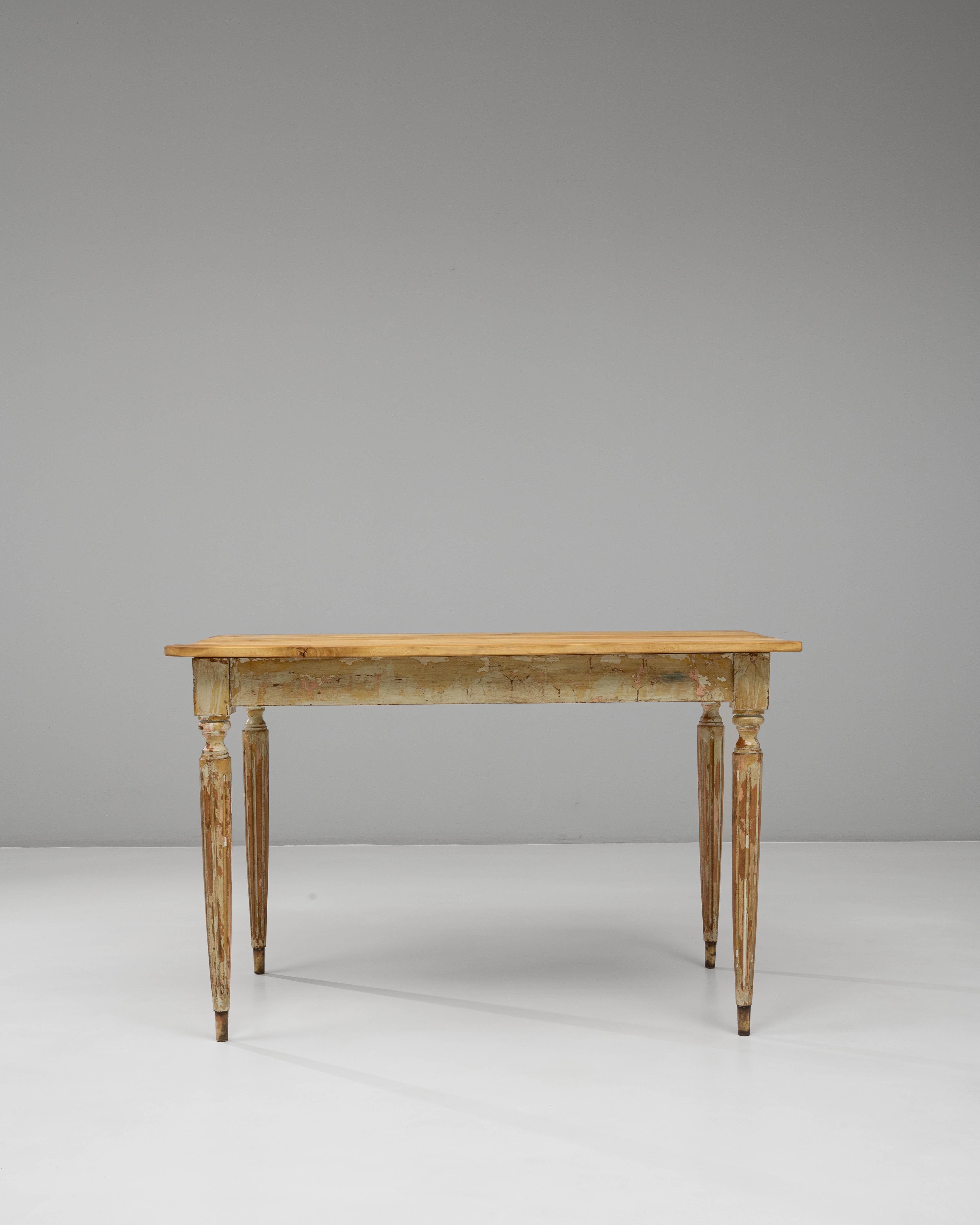 Cette table d'appoint en bois patiné de style gustavien français du XXe siècle incarne la simplicité gracieuse du style gustavien, défini par sa palette douce, ses proportions raffinées et son ornementation sobre. La base présente une surface peinte