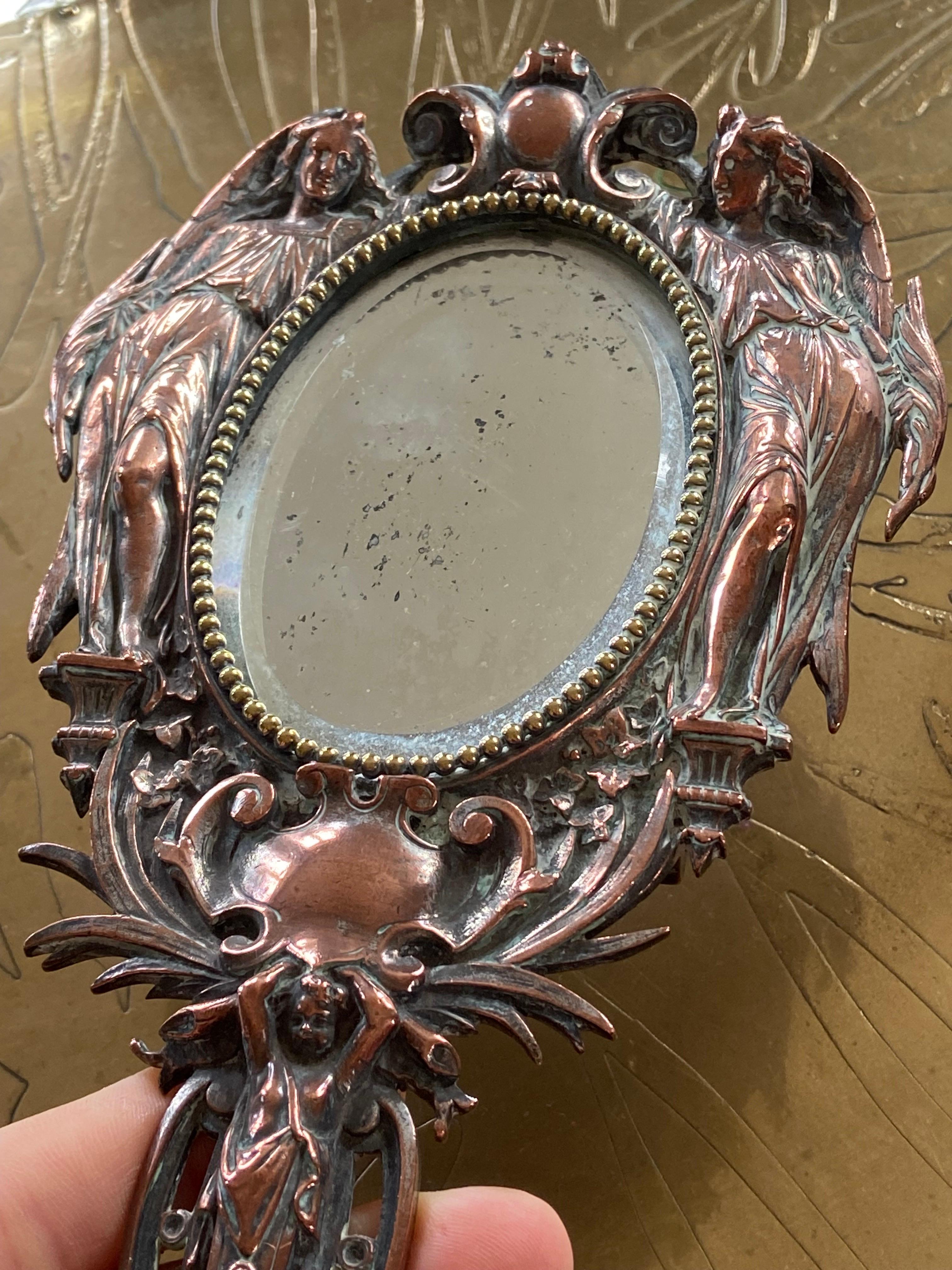 Metal 20th Century French Hand Mirror with Two Angels Surrounding the Oval Shape For Sale