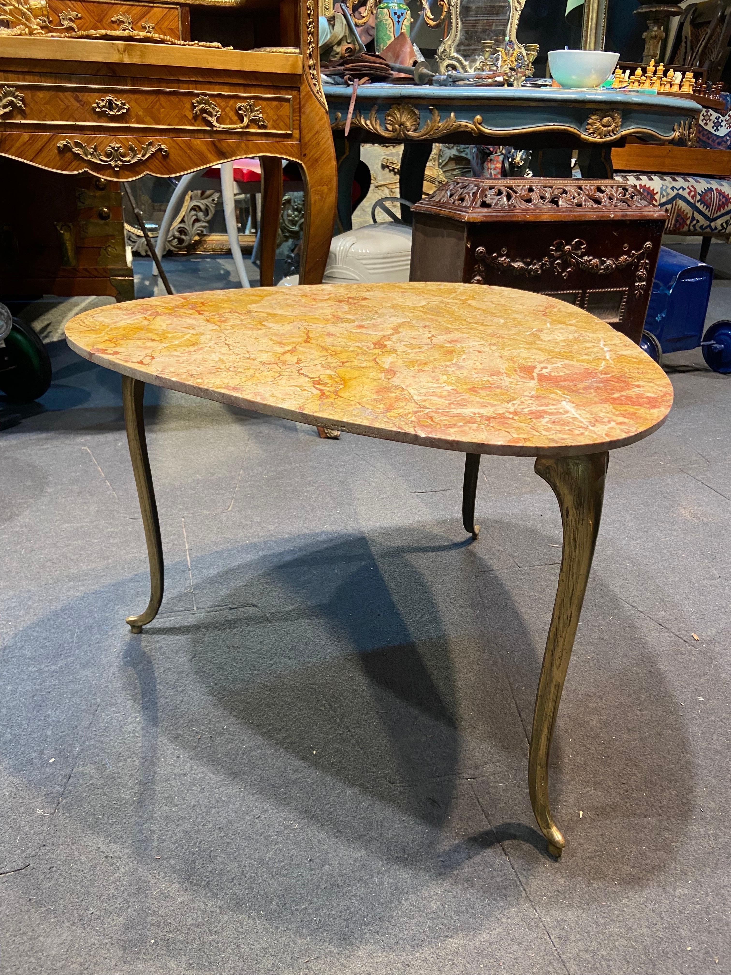 Very elegant handmade side table with yellow marble top raised on three-legged brass base with curved ends. The structure look very light but is nice and stable. 
France, circa 1940