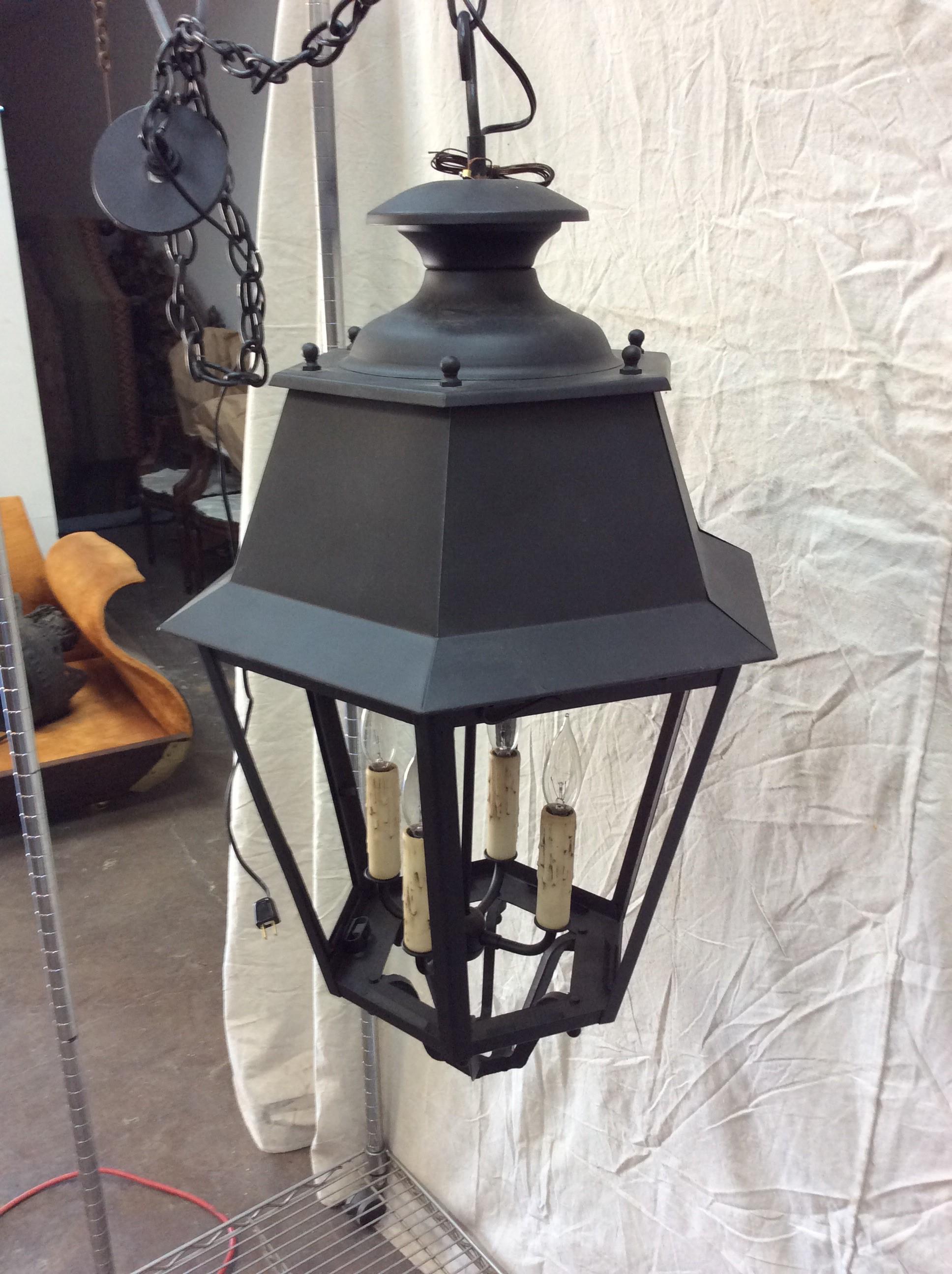 Found in the South of France, this 20th century Hanging Lantern was handcrafted in France and retains it's original finish and metal work. The wiring has been updated and features a four candelabra light cluster attached to a swivel rod. Hexagonal