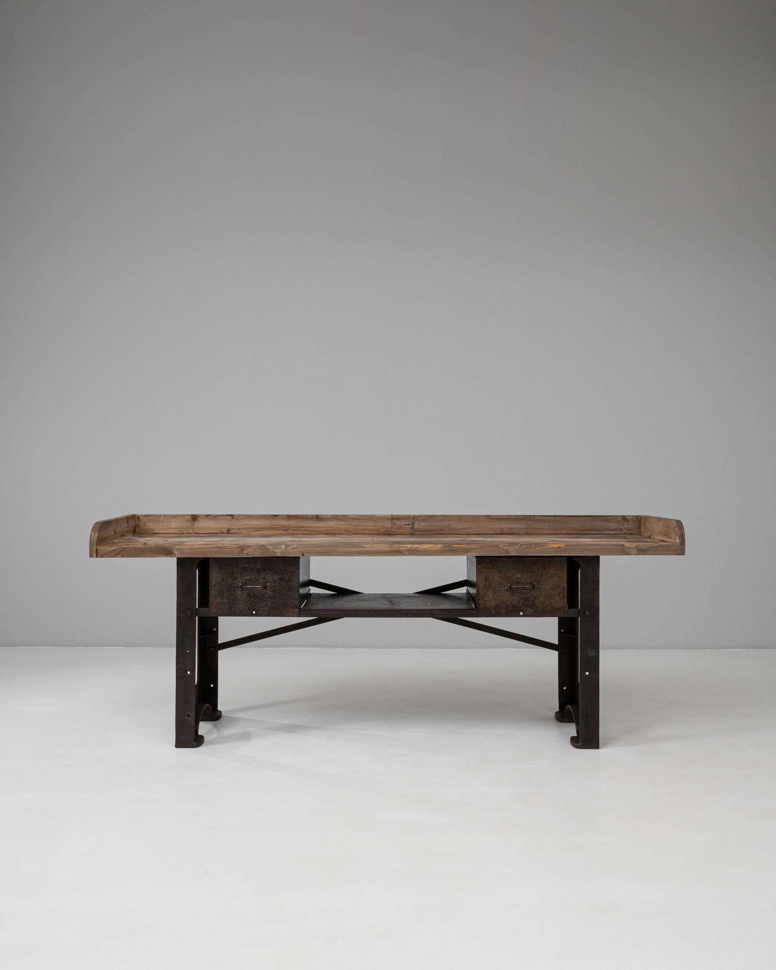 Cette table de travail industrielle française du 20e siècle est une pièce remarquable qui allie utilité et forte présence architecturale. Il se compose d'une base robuste en fonte avec des détails audacieux de découpe, des supports rivetés et une