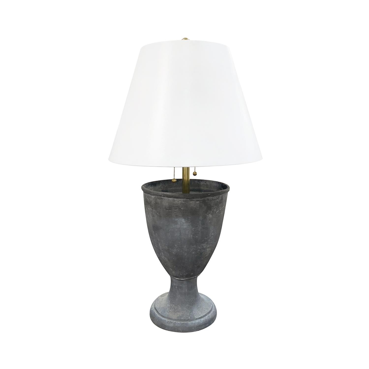 A vintage Industrial Style French pair of large table lamps made of hand crafted metal, in good condition. The vase shaped lights are composed with a new white round shade, enhanced by a polished brass beam, finial featuring a two light socket. The