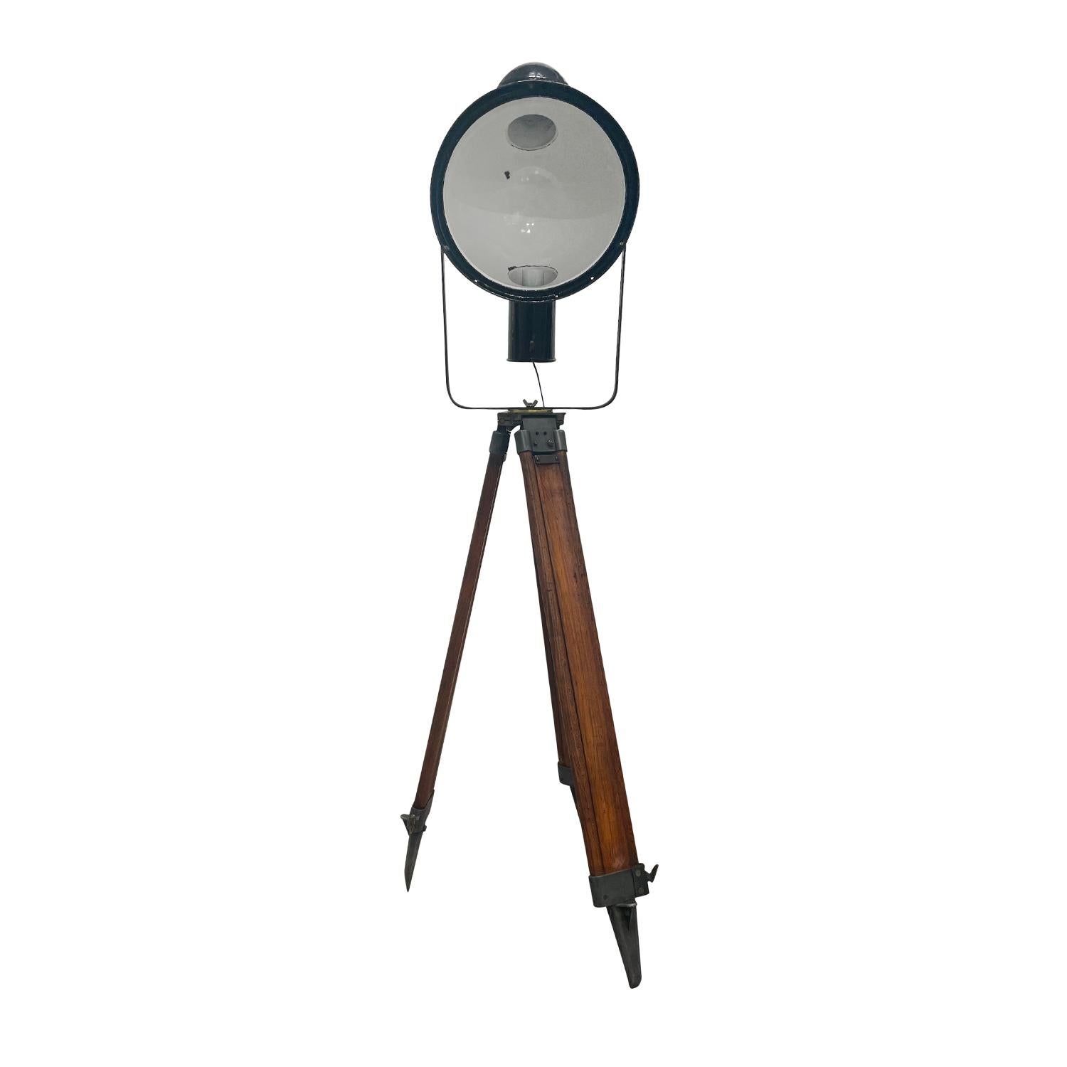 A black, vintage Industrial Style French spotlight made of hand crafted painted metal, in good condition. The detailed Parisian cinema floor studio lamp features a single light socket, consisting its original hardware, standing on an adjustable