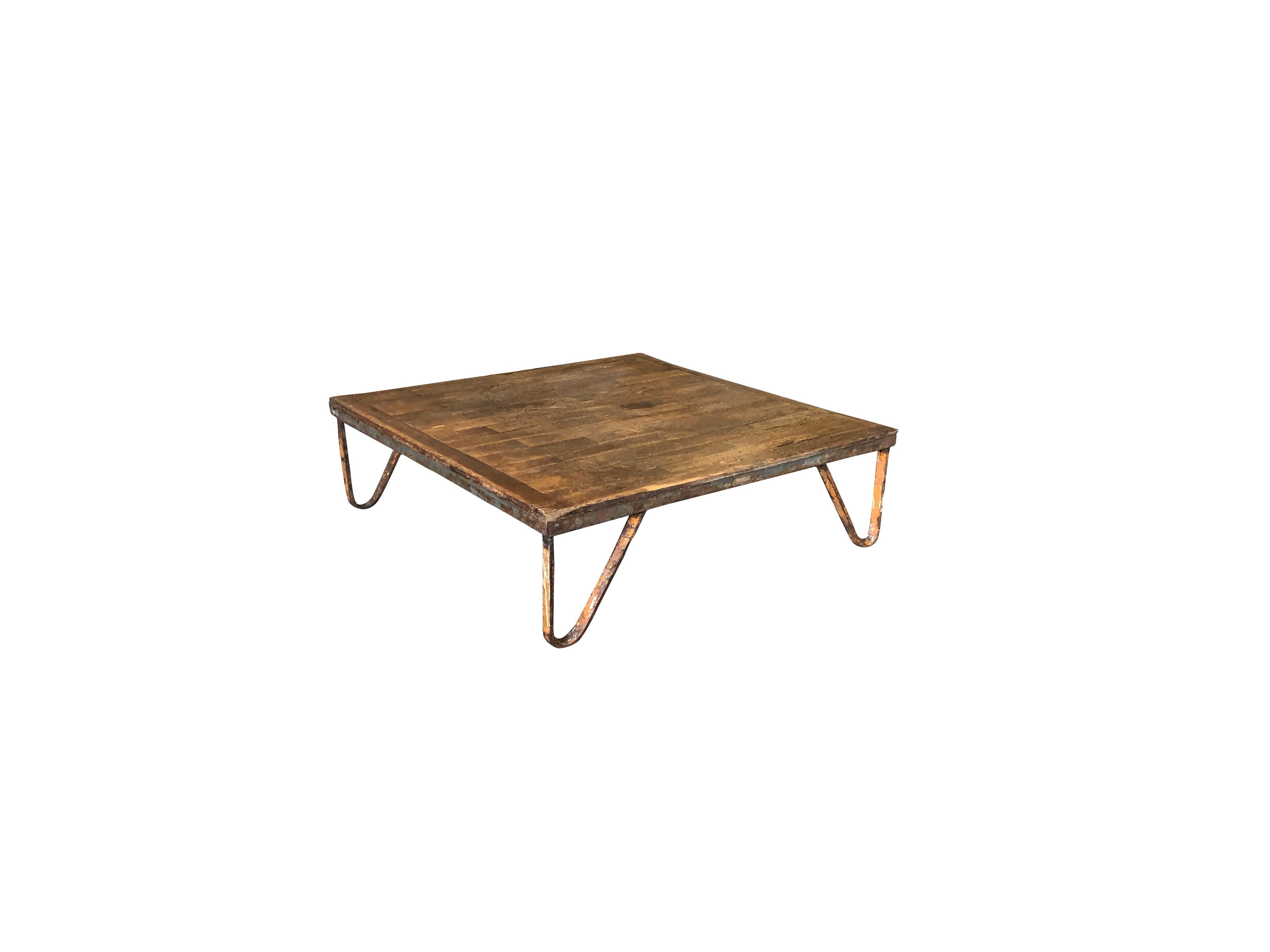 Antigua mesa de centro de estilo industrial francés de principios del siglo XX, hecha a mano en madera, en buen estado. El tablero cuadrado de la mesa baja de sofá se apoya en cuatro esculturales patas de metal. Pequeña decoloración, arañazos