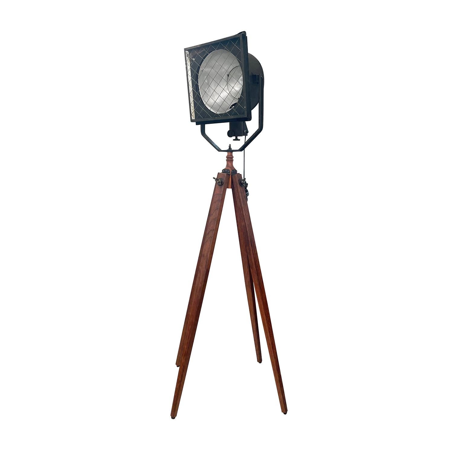 A vintage Industrial French spotlight made of hand crafted metal, in good condition. The detailed theater, cinema studio lamp is composed with a large adjustable rectangular shade, featuring a single light socket. The cinema lamp is standing on four