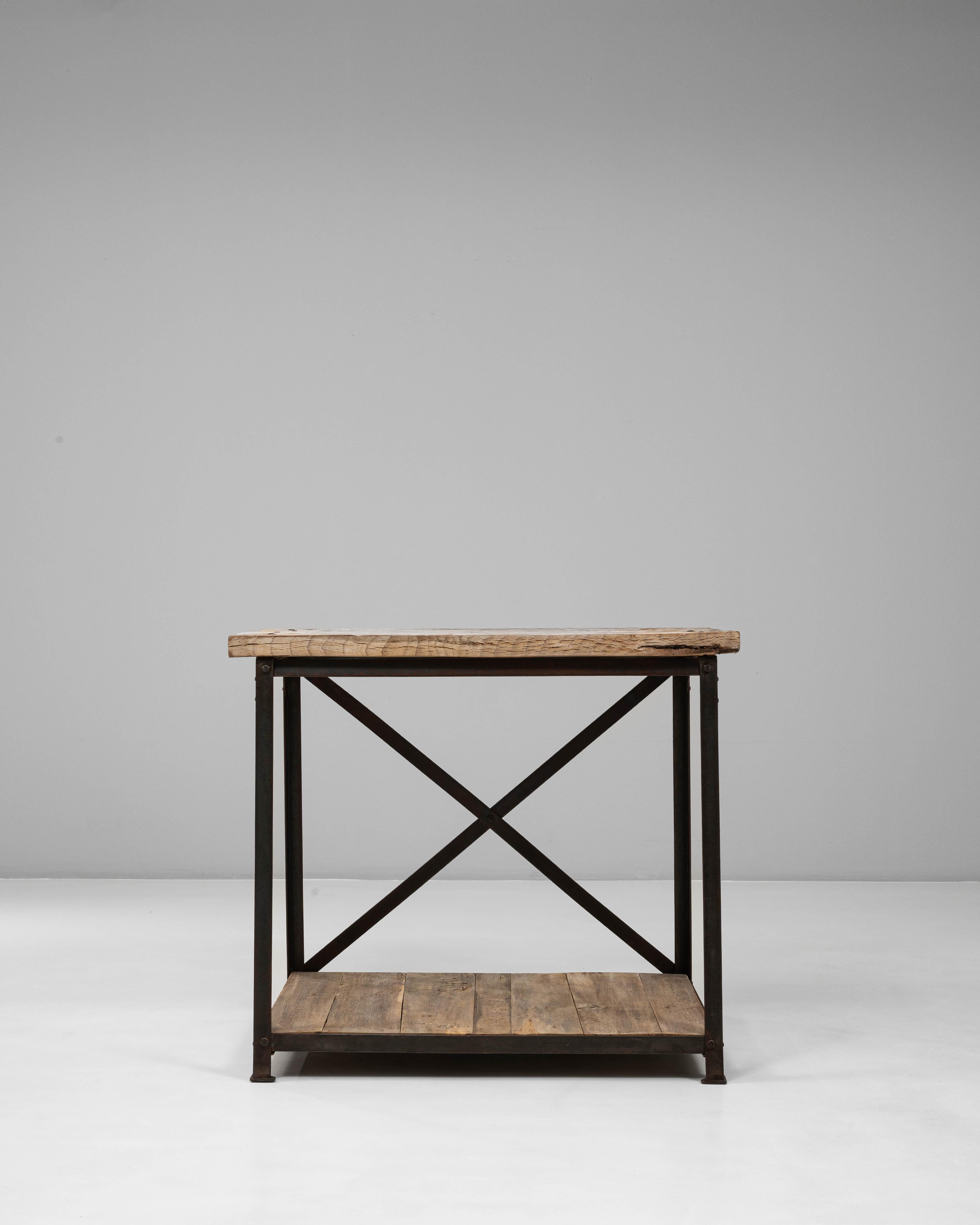 Cette table industrielle française du 20e siècle en bois sur une base en métal combine une structure utilitaire avec un caractère chaleureux et usé par le temps. Le plateau en bois épais, marqué par des motifs de grain visibles et une texture