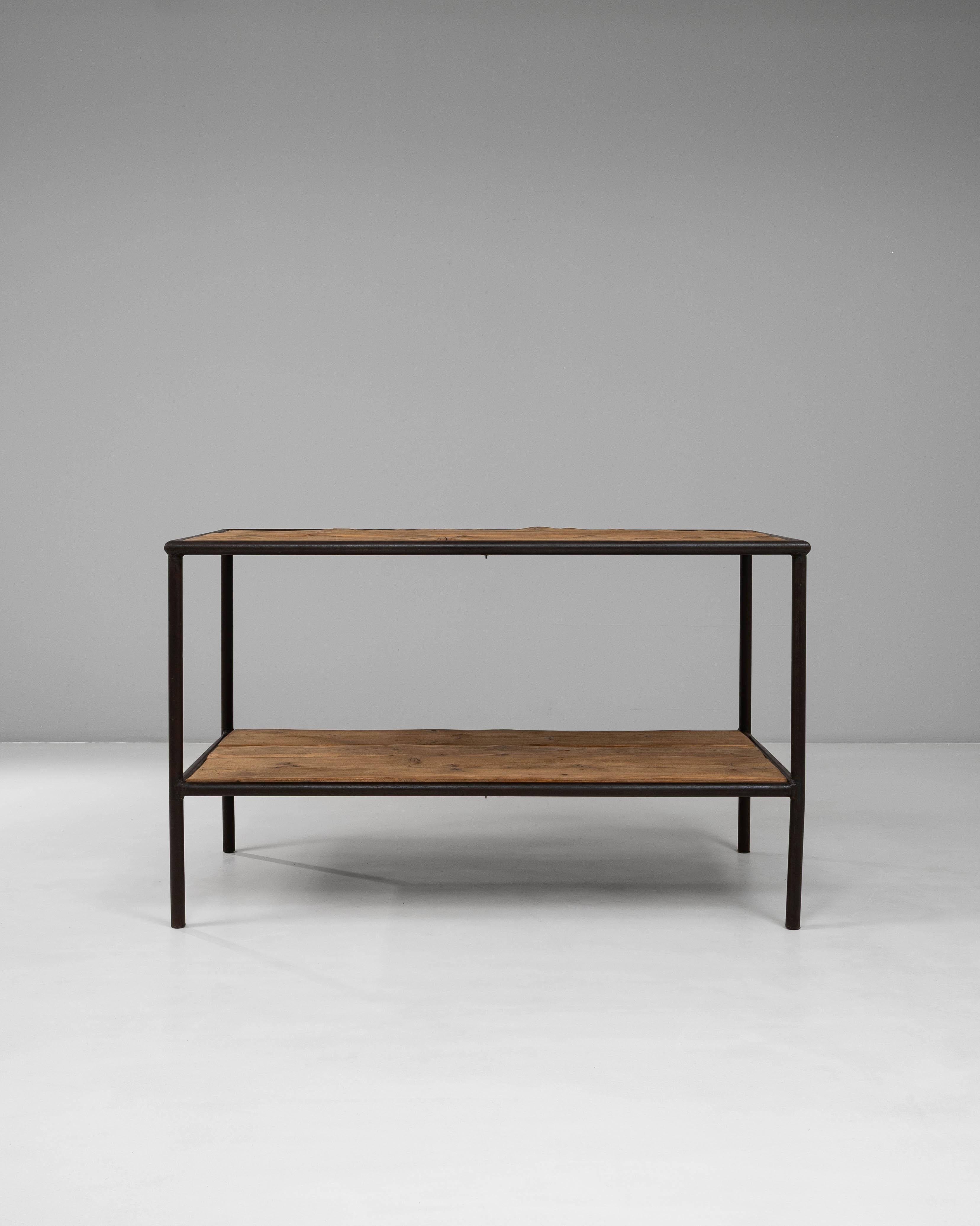 Cette table industrielle française du 20e siècle en bois sur une base en métal allie la simplicité fonctionnelle à un caractère chaleureux et usé par le temps. L'armature métallique élancée, finie dans une patine sombre, forme une structure linéaire
