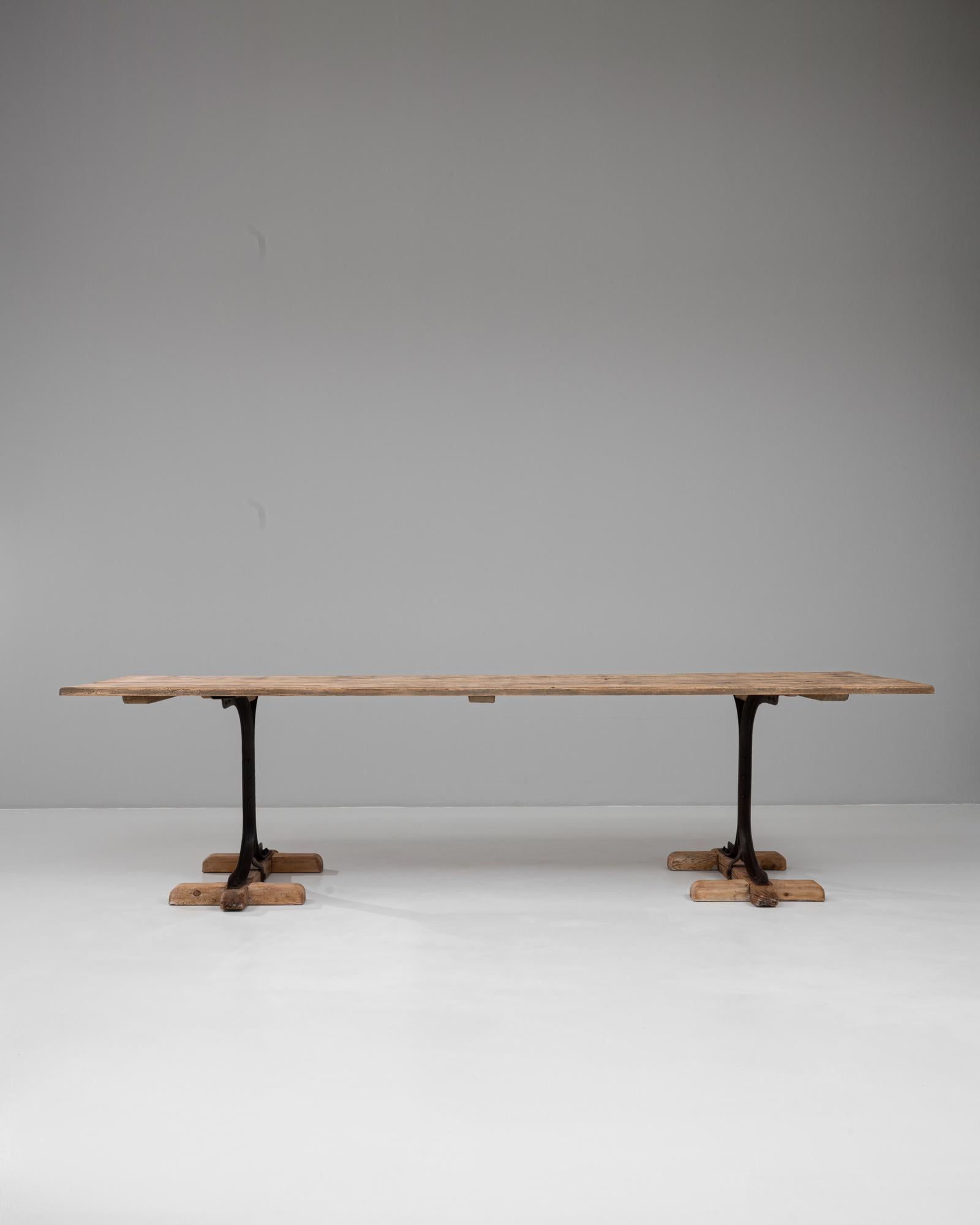 Cette table industrielle française du 20e siècle en bois sur tréteaux métalliques combine une utilité robuste avec un style discret. La table présente un plateau en bois solide et usé par le temps, avec une patine naturelle qui révèle son âge et son