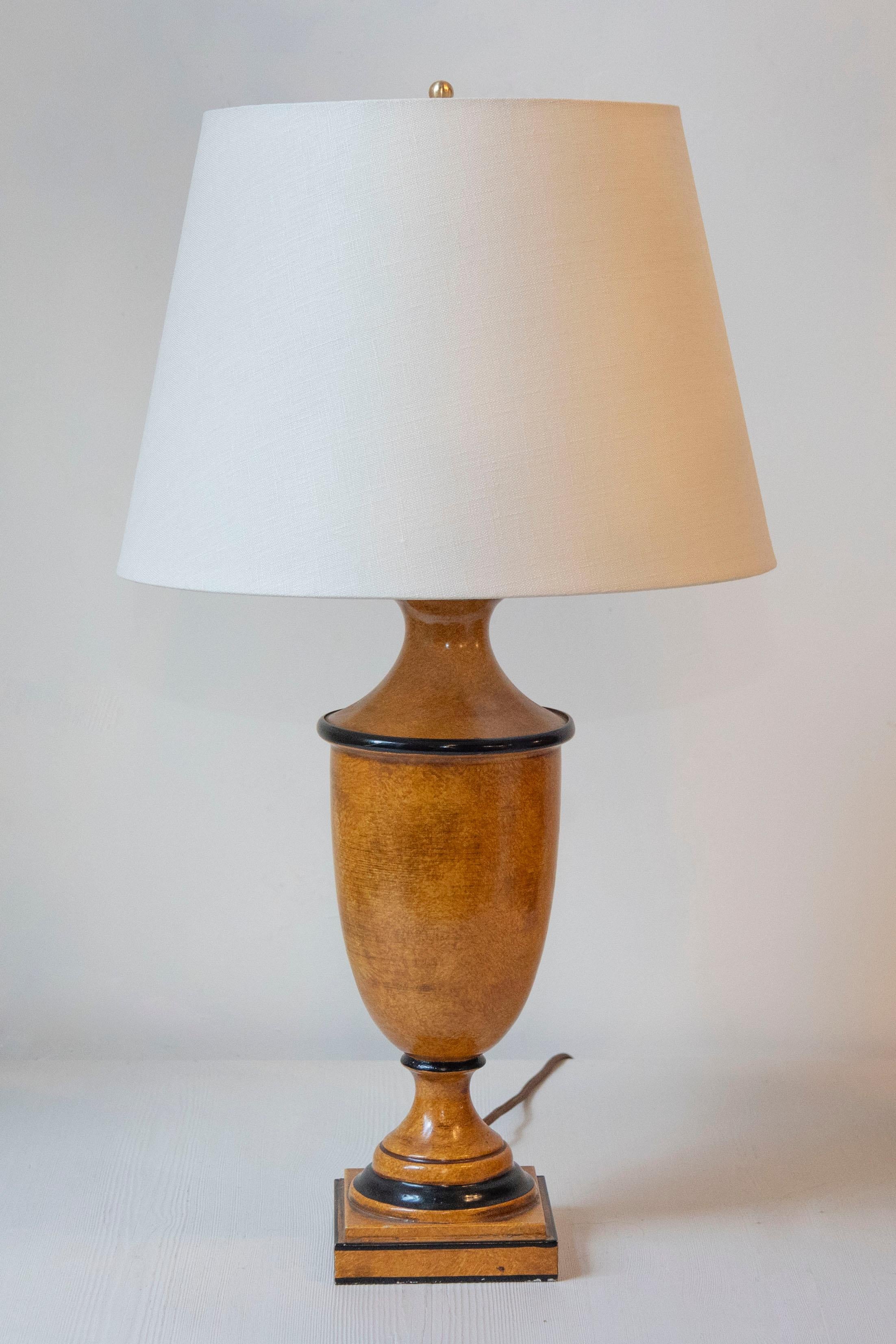Esta lámpara del siglo XX, fabricada en chapa pintada, presenta un llamativo acabado amarillo ocre acentuado con elegantes detalles de hilo negro. El diseño presenta un cuerpo clásico en forma de urna sobre una base cuadrada, que combina una