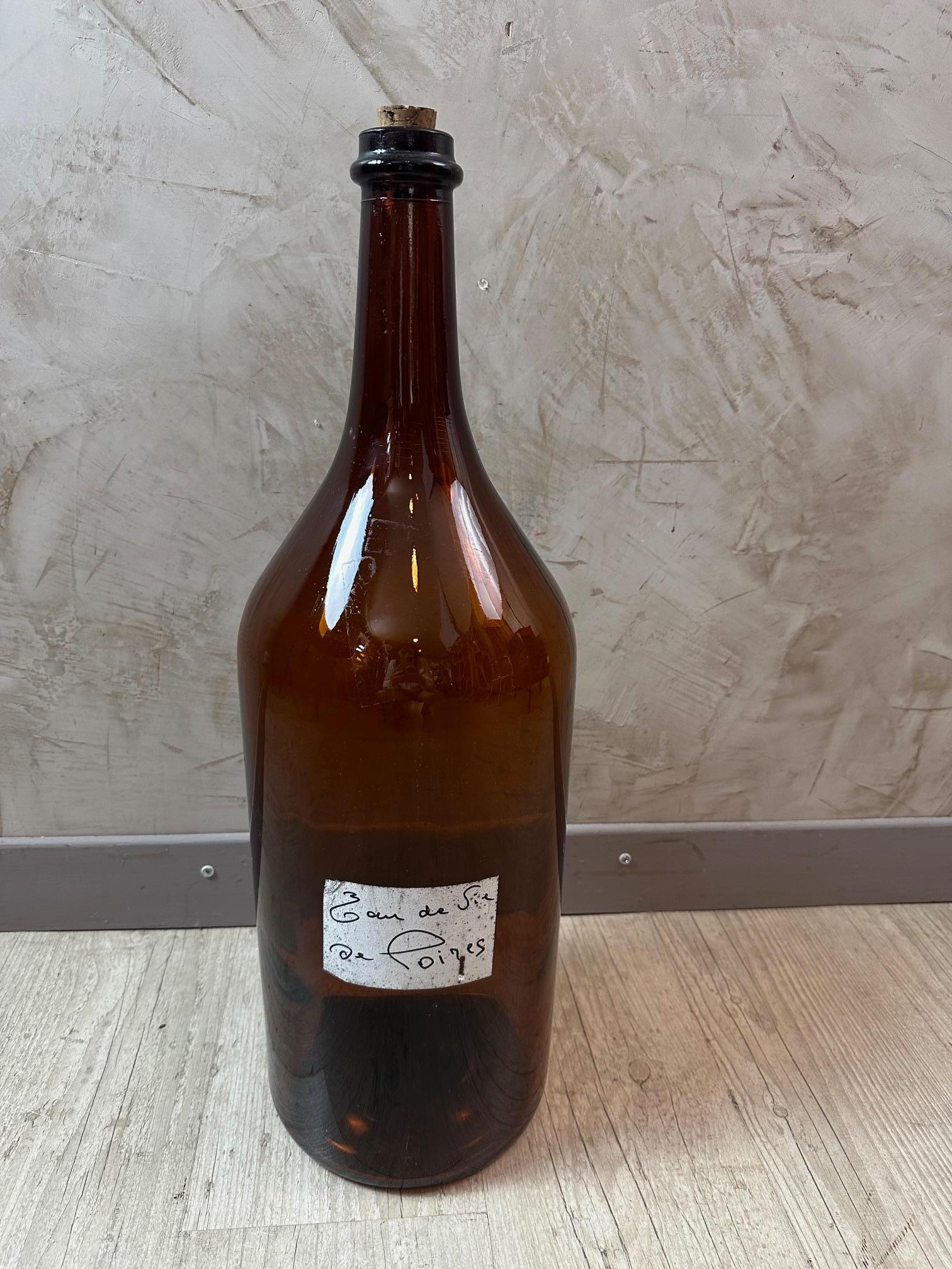 Gran botella francesa de vidrio ámbar del siglo XX en Bueno estado para la venta en LEGNY, FR