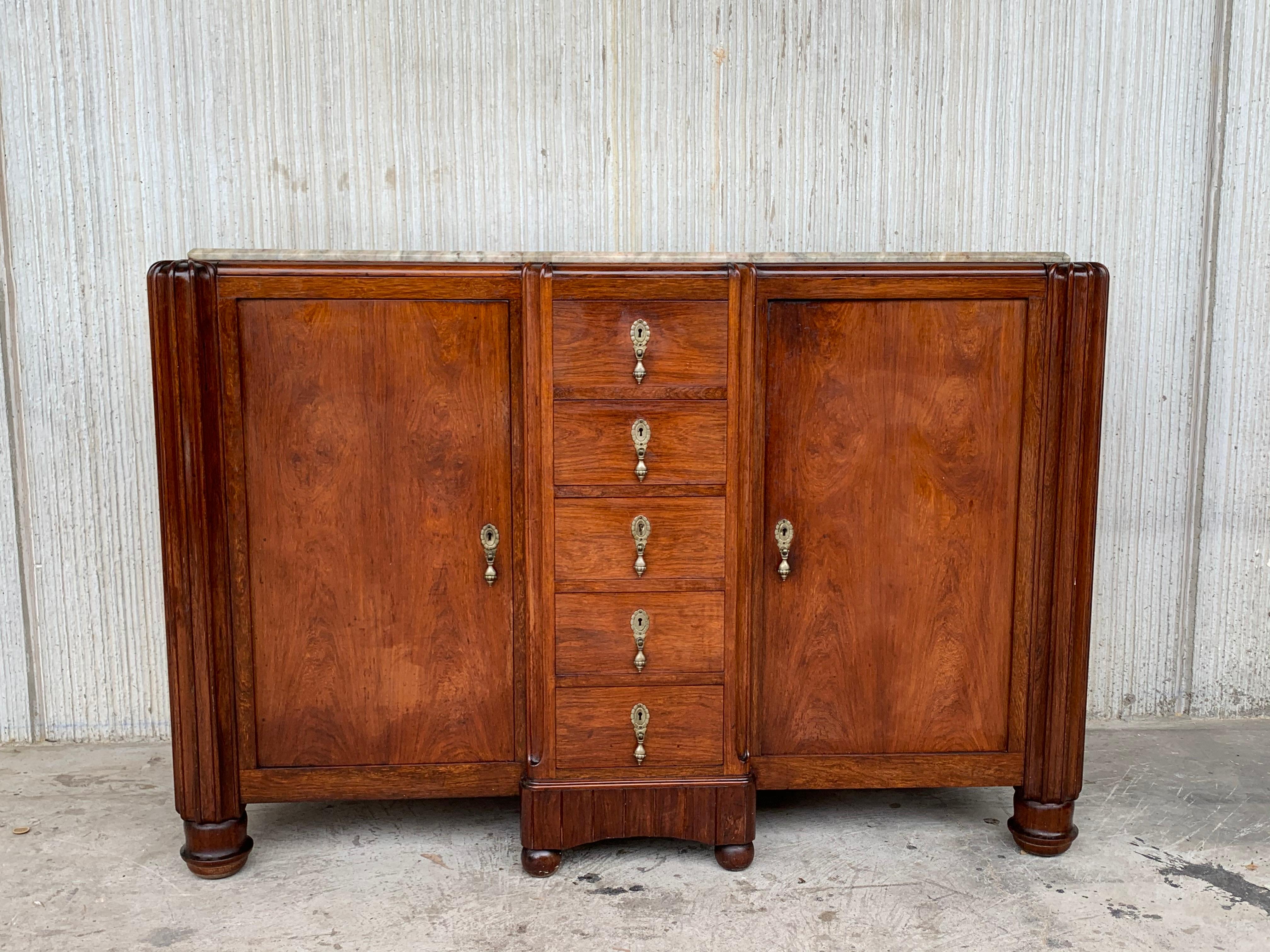 An Art Deco sideboard with burr walnut wood and marble top, with Satin fluted colums in both sides and banding. Five integral central drawers with original moss green handles. 

 