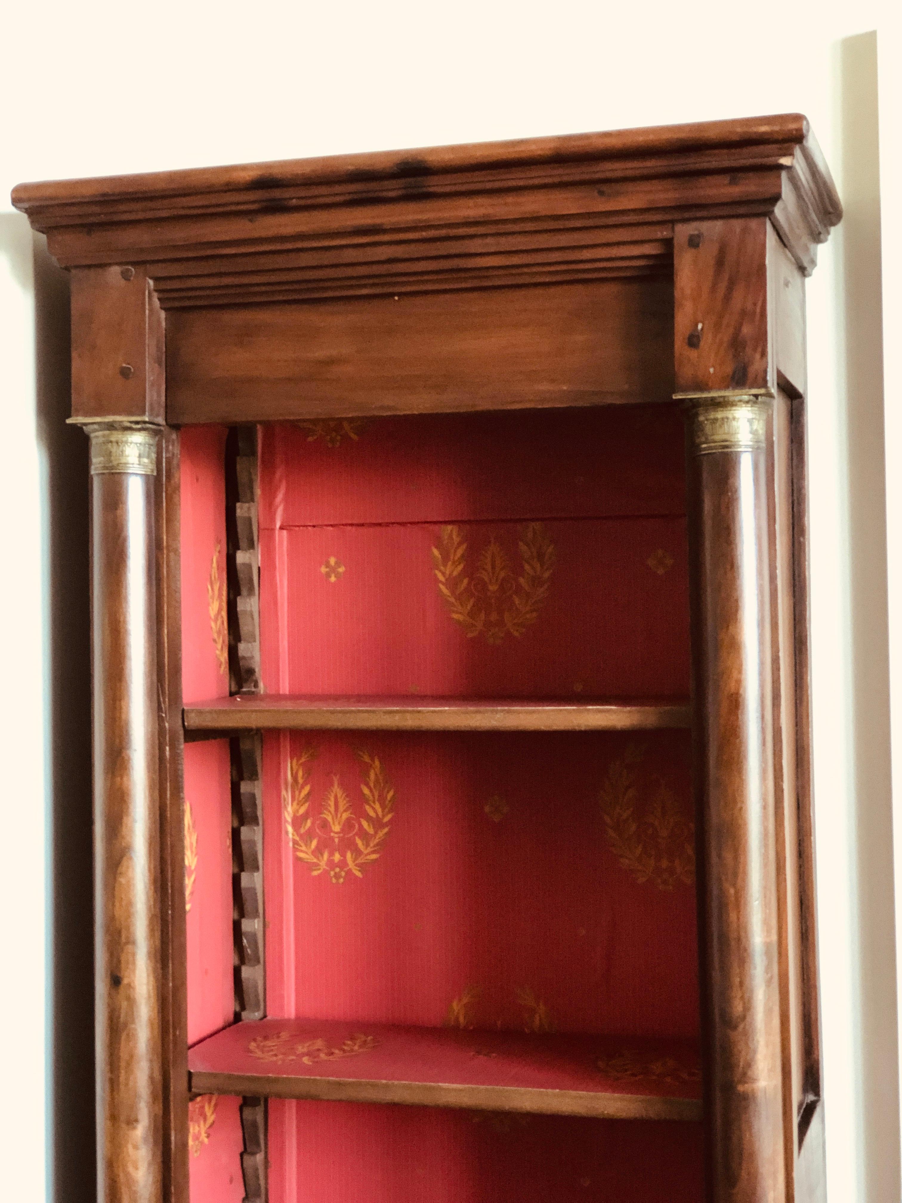 French hand carved mahogany bookcase in Empire style upholstered with red paper with gold decorations.
Three adjustable shelves.
France, circa 1920.
