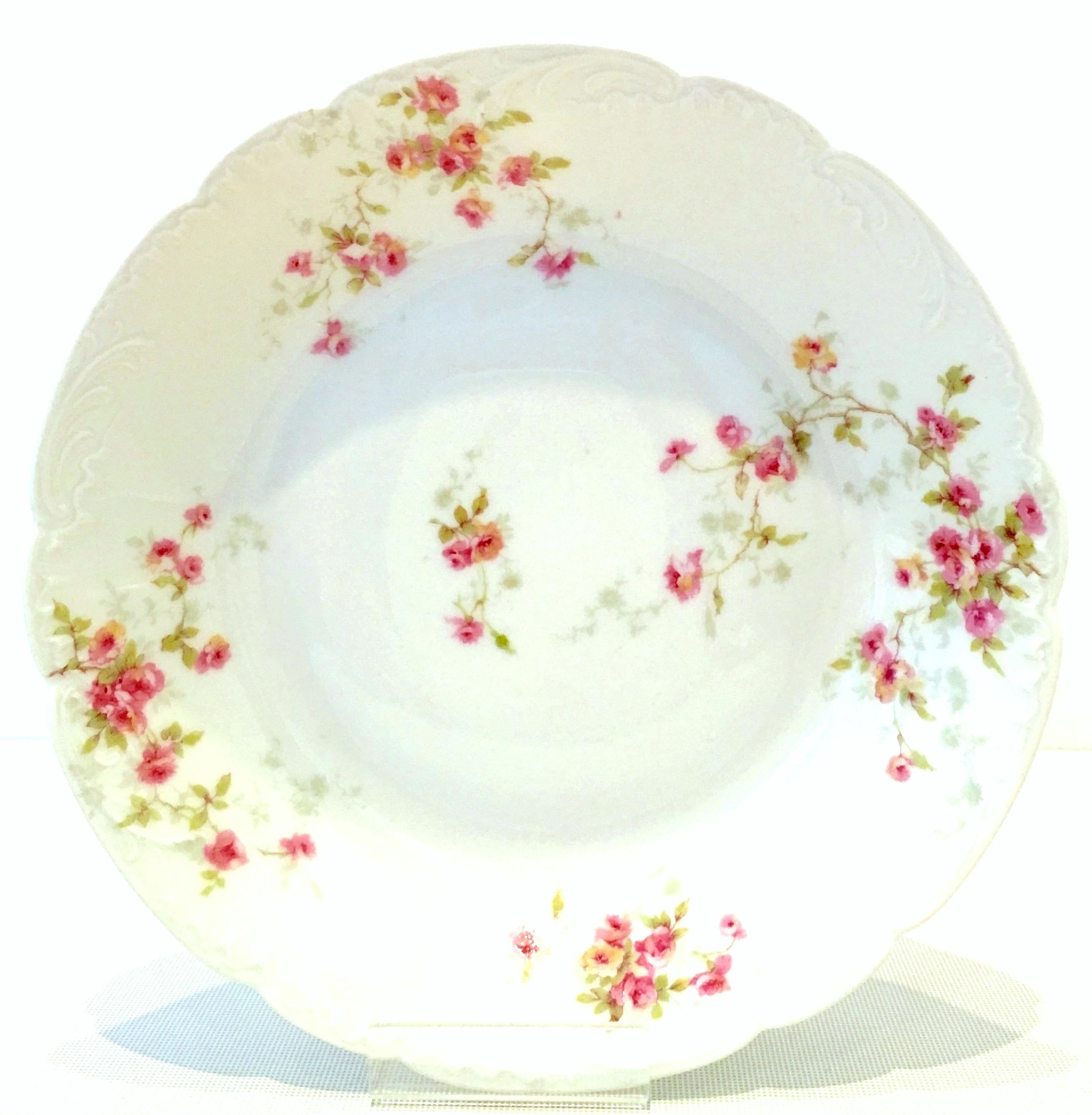 20th Century French Limoges dinnerware set of seven pieces by, Theodore Haviland. Set features a bright white ground with scalloped shape detail, hand painted in a bright pink and green flowing rose pattern. Set includes four coupe soup bowls and