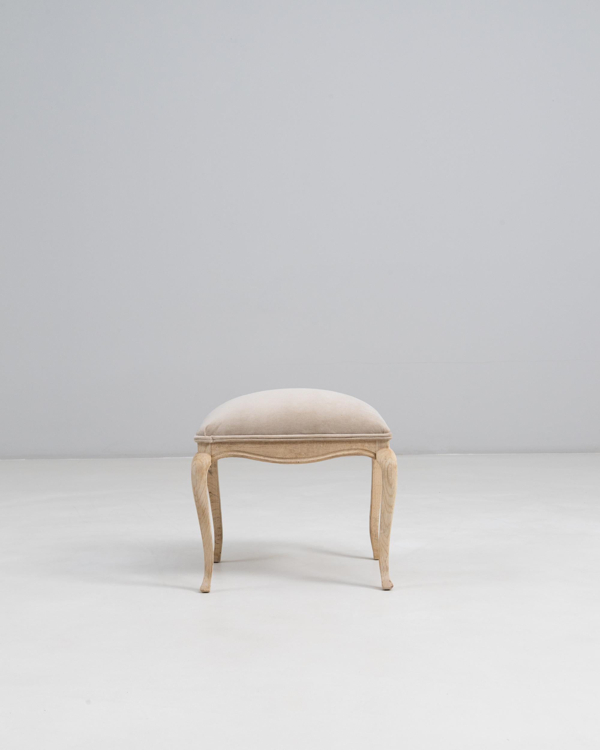 Taburete Francés Luis XV de Roble del Siglo XX con Asiento Tapizado. Este elegante taburete captura las suaves curvas y las refinadas proporciones características del estilo Luis XV. Realizada en roble con una ligera pátina natural, presenta