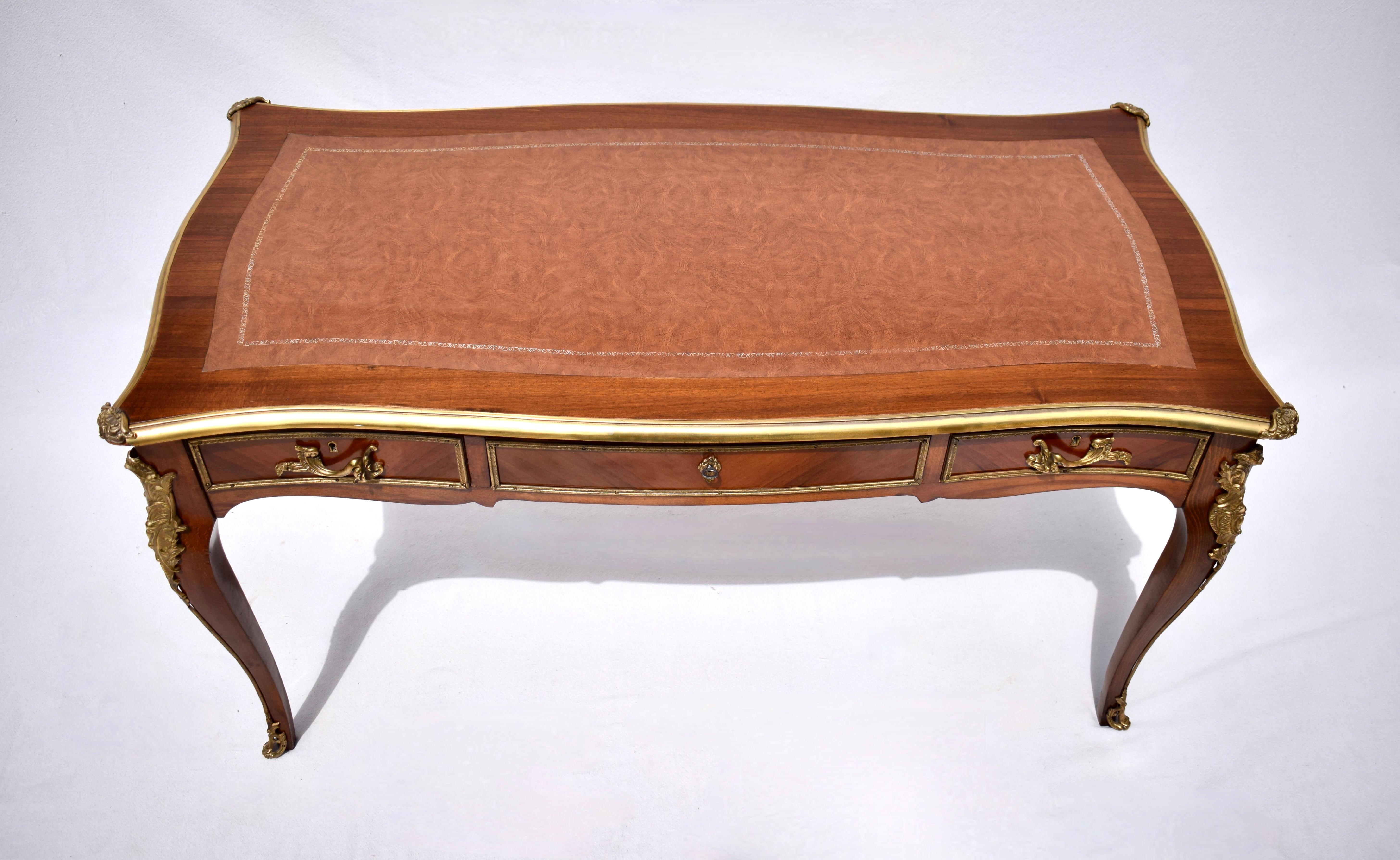 Exceptional 20th Century Kingwood Louis XV-style Bureau Plat featuring original gold-embossed leather top with highly detailed brass accents, trim & mounts. Finished on all sides this exquisite mid size desk boasts three drawers with working locks &
