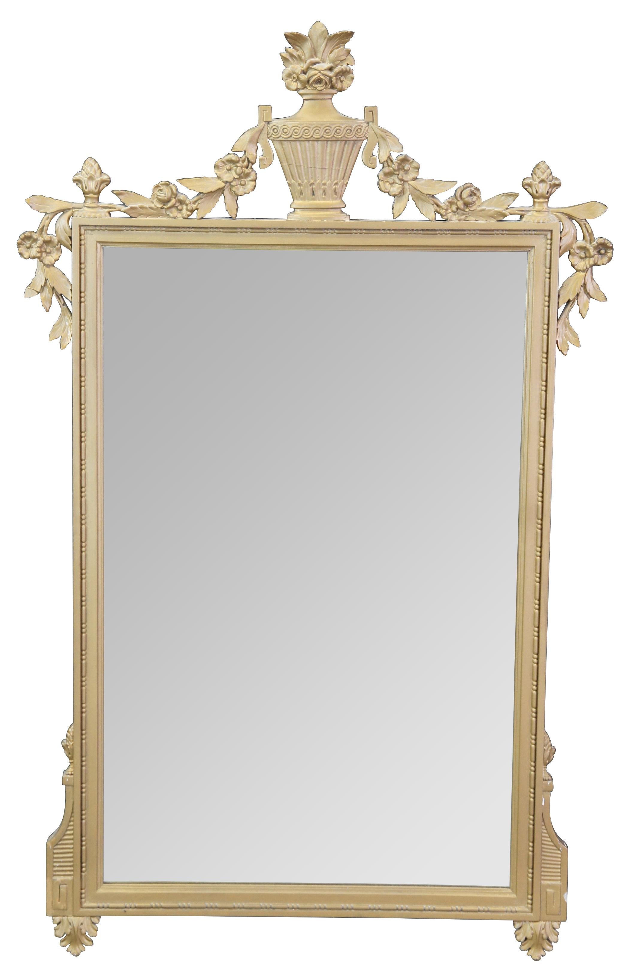 A beautiful mid 20th century Louis XV style wall hanging mirror. Attributed to Robert W. Irwin. Finished in gold with grecian urn finial at the center and floral boquet, flanked by foliate, flowers and acorn finials.