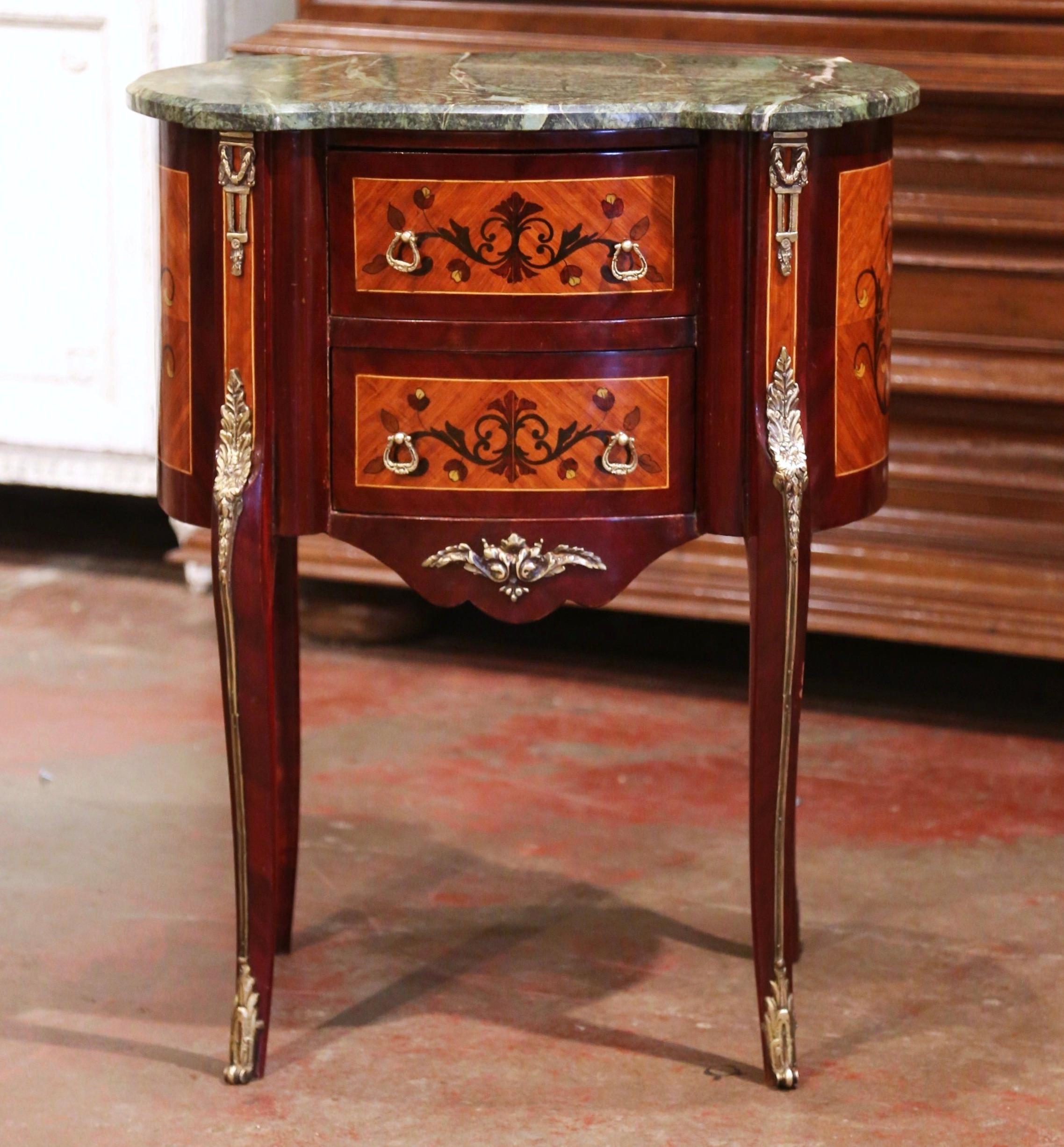 This elegant, kidney-shaped fruitwood antique commode was crafted in France, circa 1980.The commode sits on cabriole legs ending with brass sabots over a scalloped apron embellished with a center decorative brass mount. The front features two