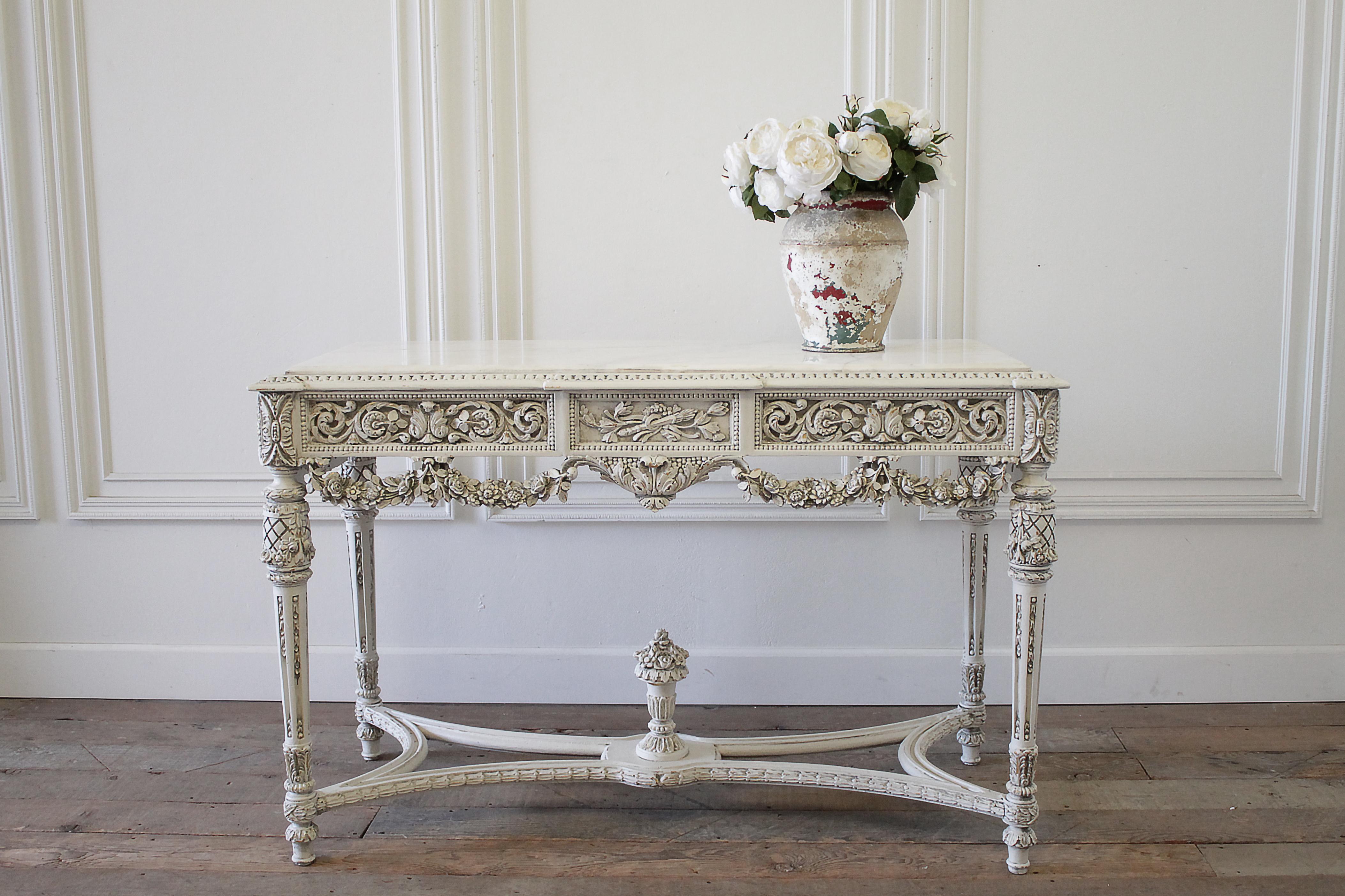 20th century French Louis XVI style carved wood and marble console table
Painted in our oyster white finish with light subtle distressed edges, and antique glazed patina.
Beautiful rose swag carvings, and fluted legs. This table is solid and