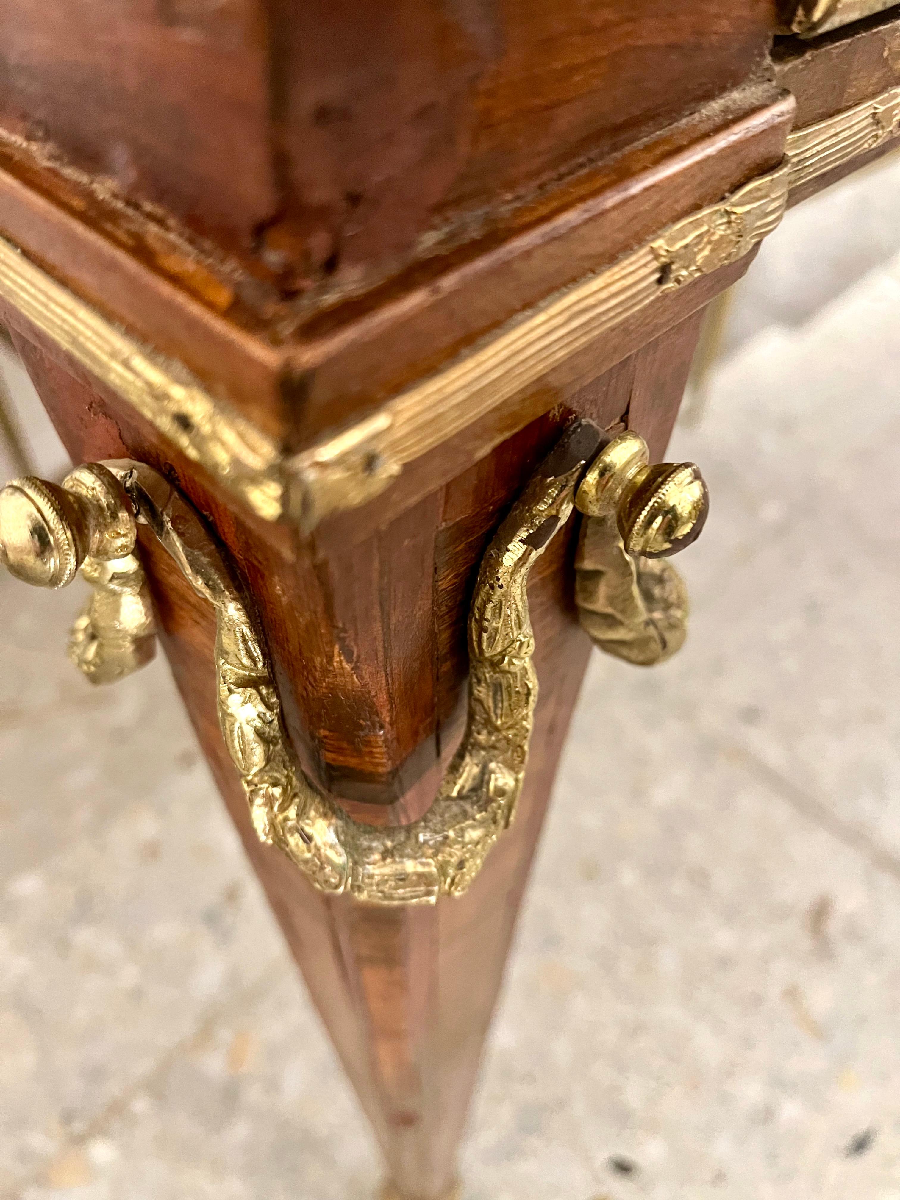 Elegante escritorio de estilo Luis XVI, fabricado en Suecia, decorado con marquetería de diseño neoclásico griego en diversas maderas frutales y de nogal. Patas estriadas, acabadas en vaina o sabot, y tablero de cuero con el borde grabado en oro,