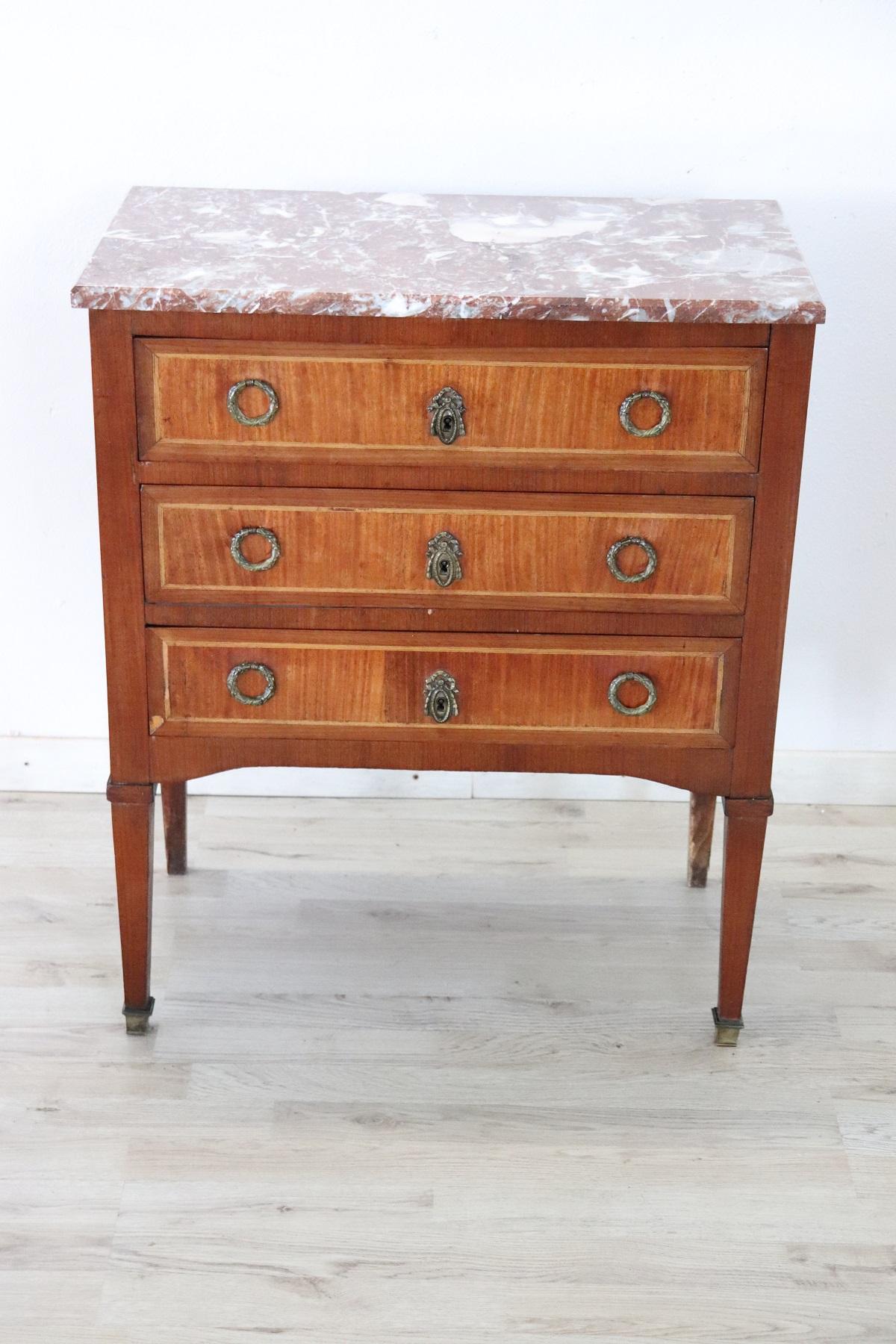 Particular small antique Louis XVI style dresser made in the early decades of the 20th century. Very elegant walnut with characteristic profiles in inlay wood, precious red marble top. On the front three comfortable drawers. The small size and